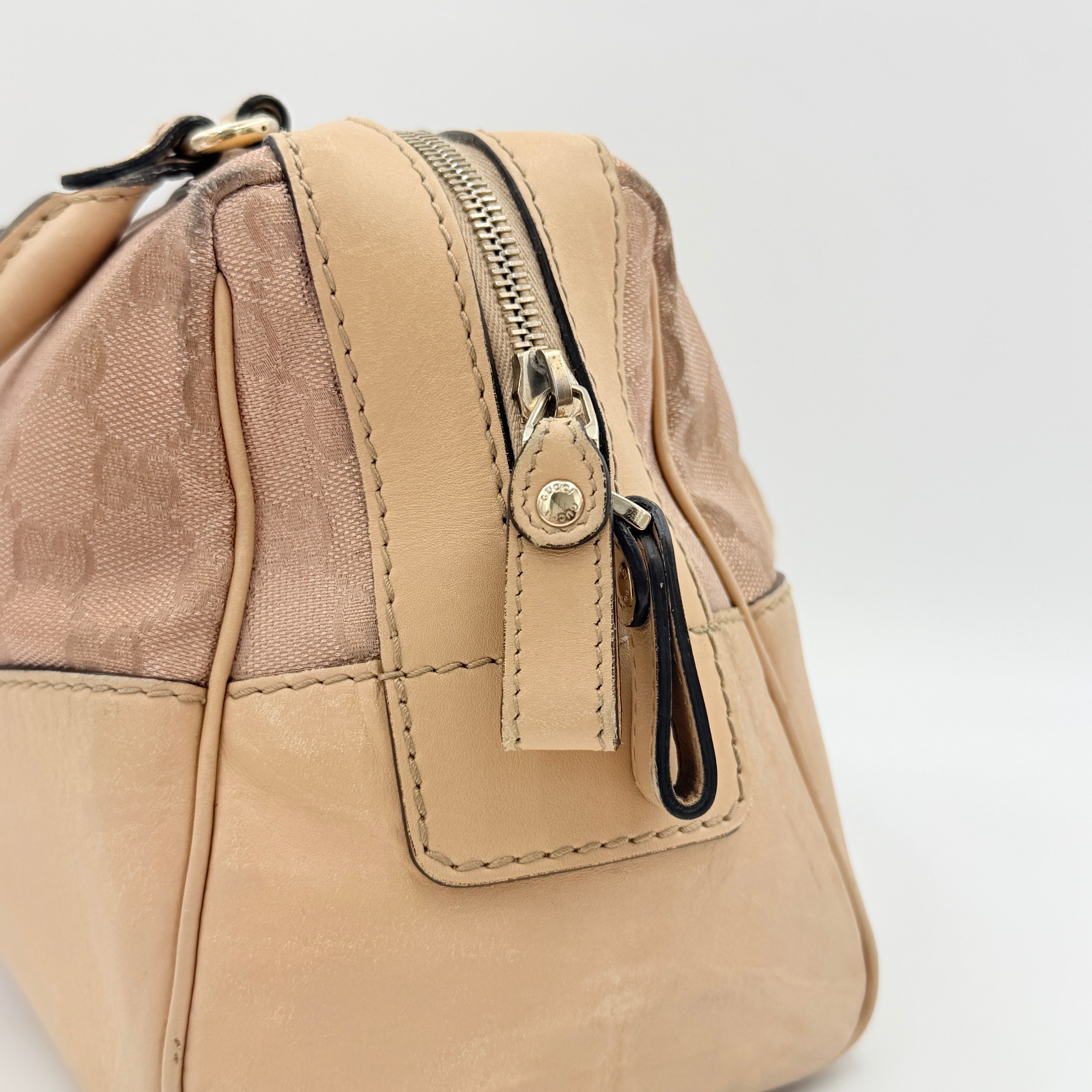 Gucci GG Monogram Heart Lovely Boston Bag in beige and pink with gold heart logo and double handles, displayed against a plain background.