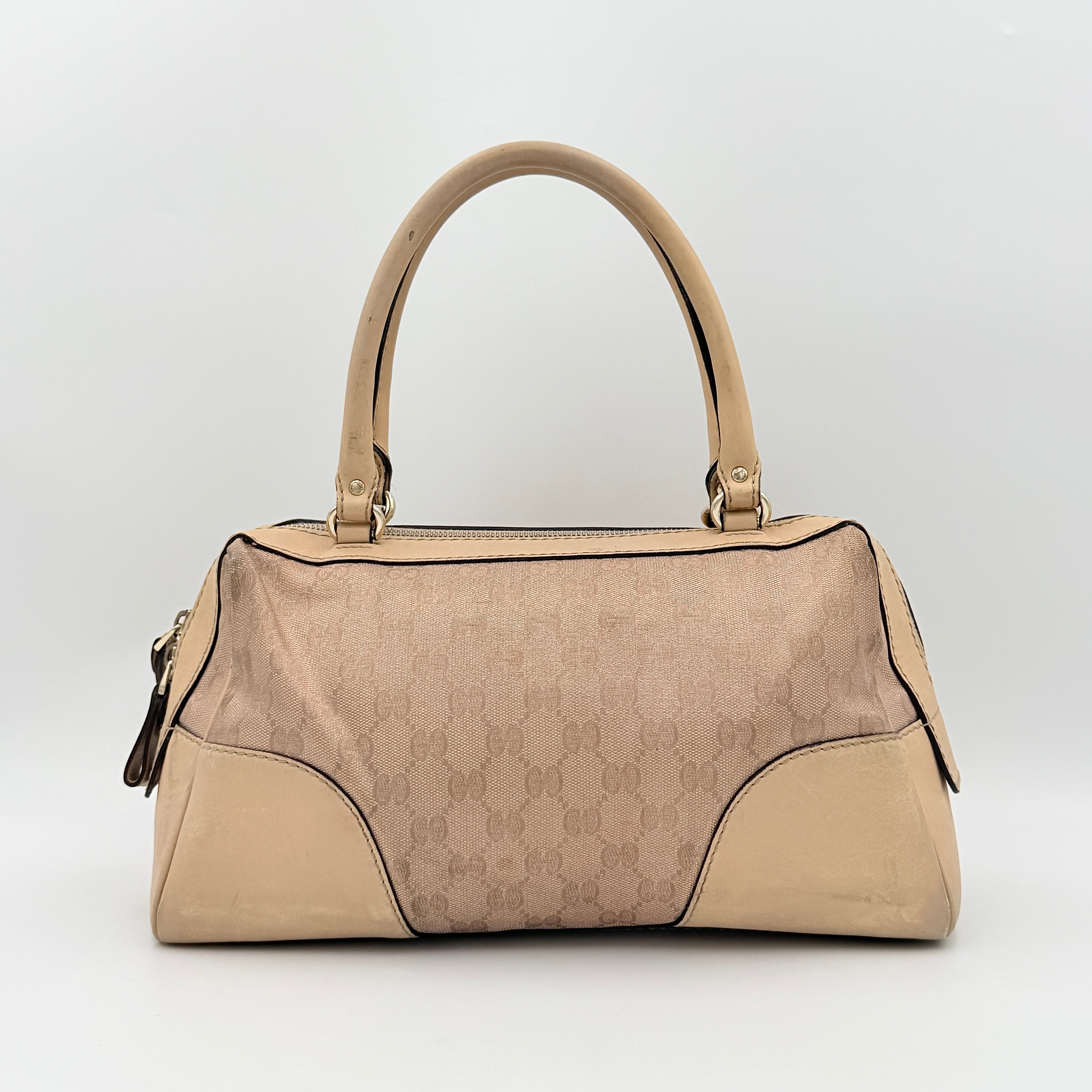 Gucci GG Monogram Heart Lovely Boston Bag in beige and pink with gold heart logo and double handles, displayed against a plain background.