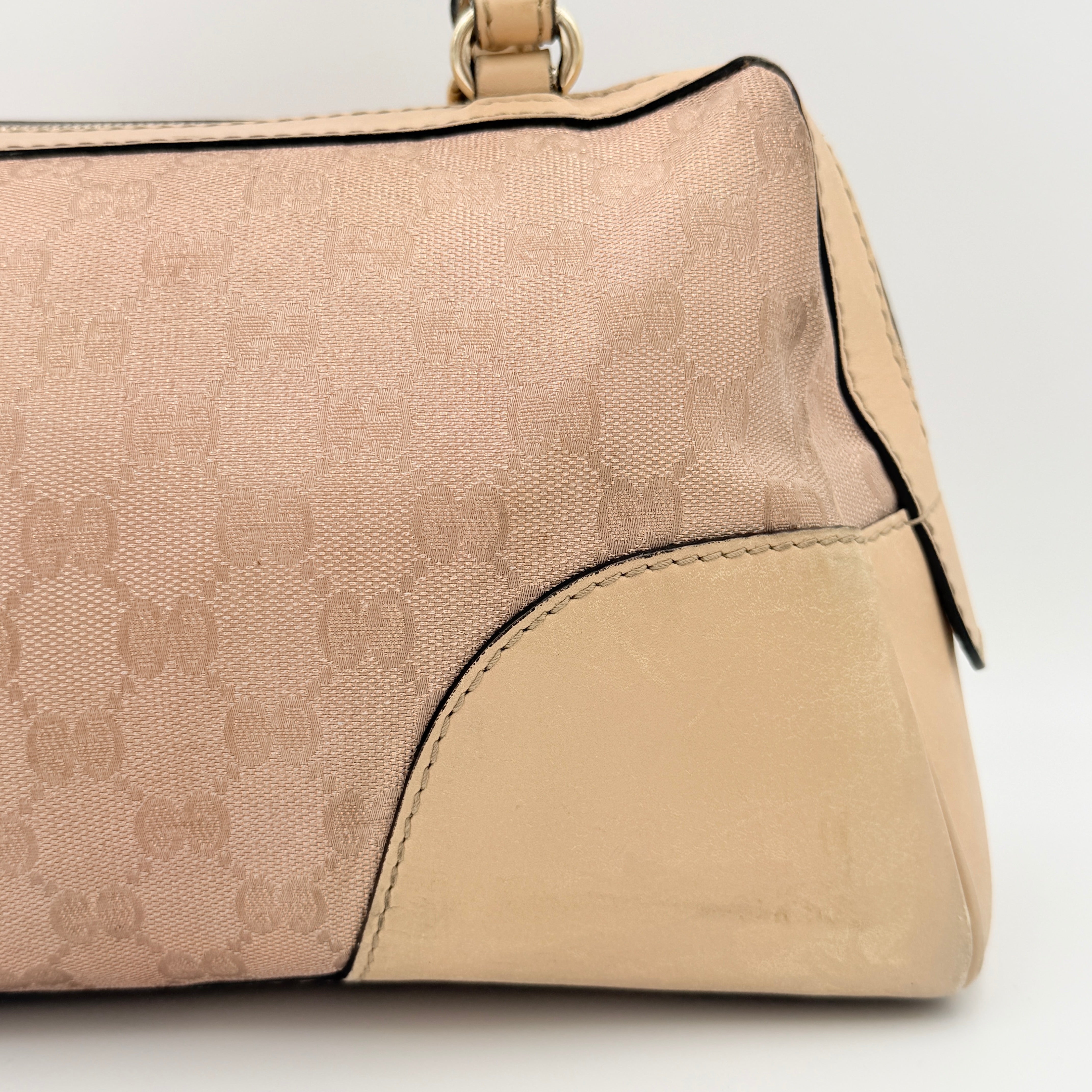 Gucci GG Monogram Heart Lovely Boston Bag in beige and pink with gold heart logo and double handles, displayed against a plain background.