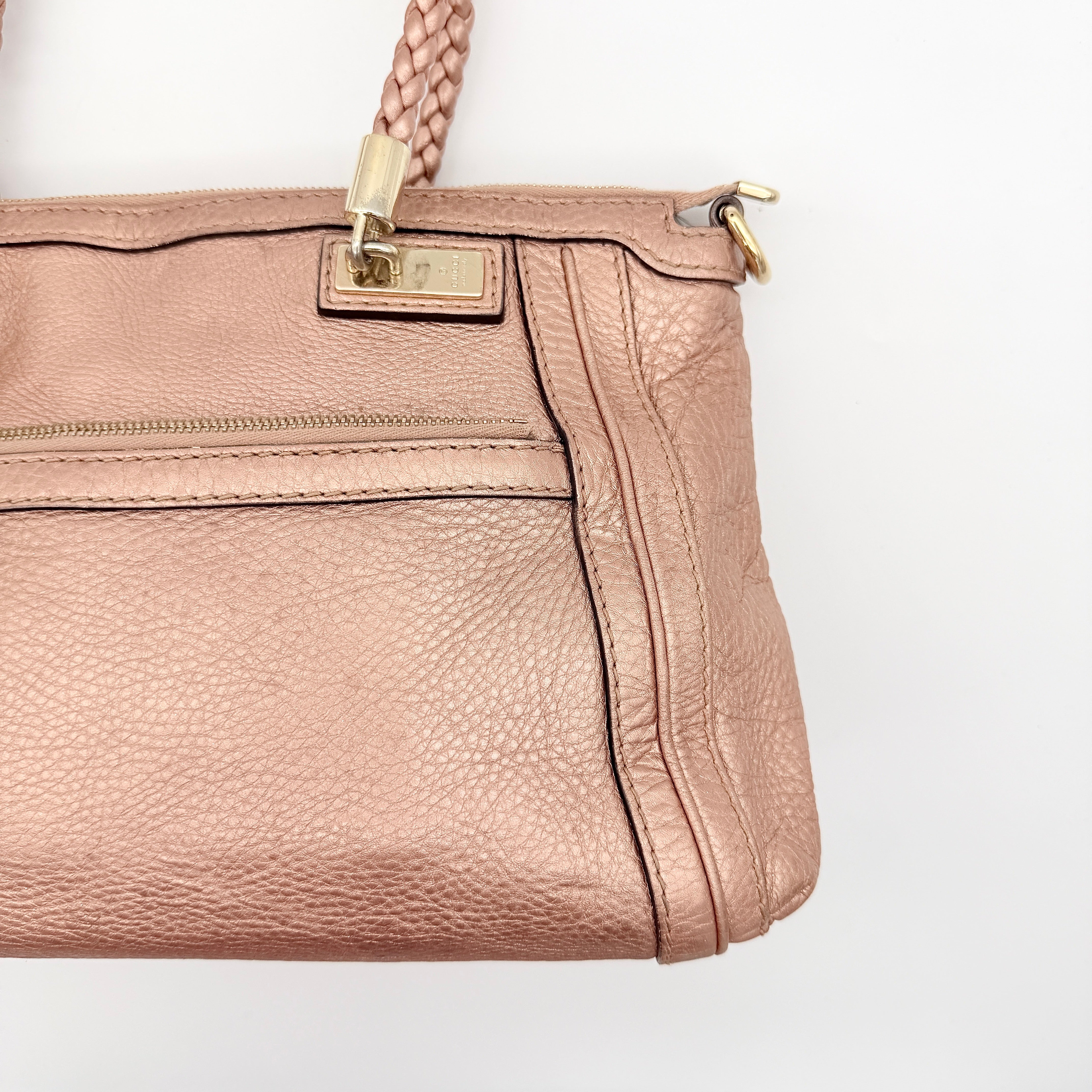 Gucci Bella Bamboo 2Way shoulder bag in metallic pink leather with braided handles and bamboo tassel accents, displayed with a detachable strap.