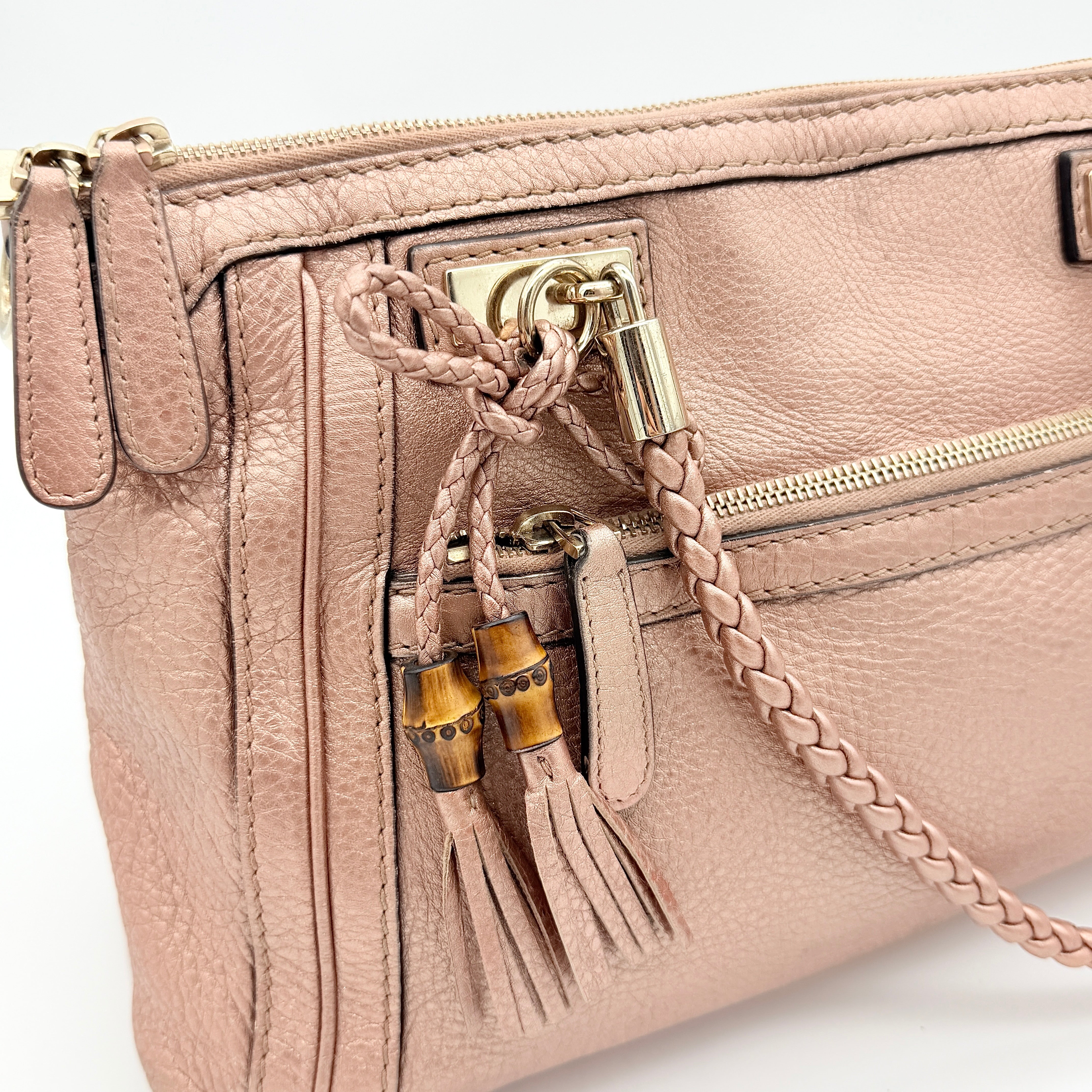 Gucci Bella Bamboo 2Way shoulder bag in metallic pink leather with braided handles and bamboo tassel accents, displayed with a detachable strap.