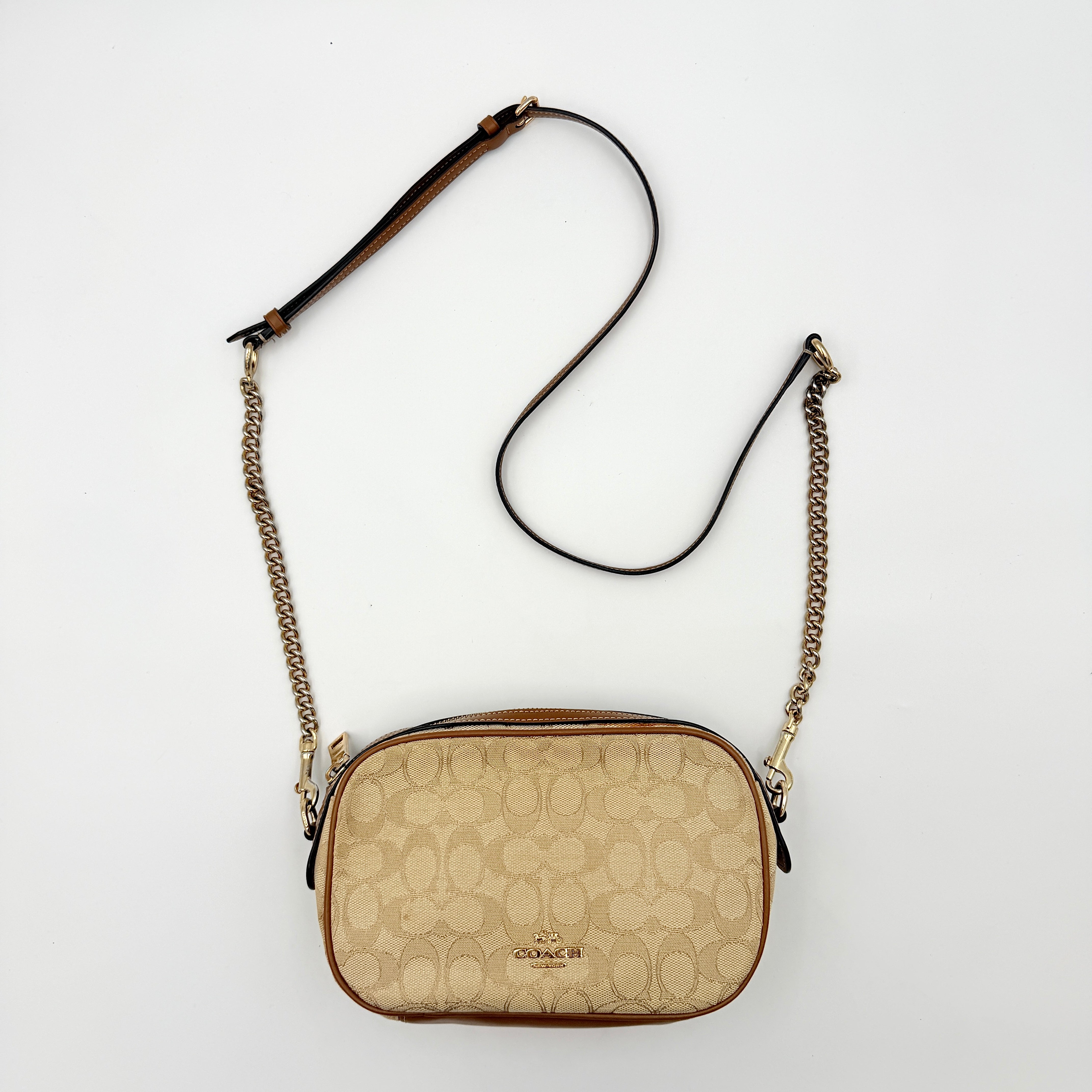 Coach Signature Isla Chain Crossbody Bag in beige and brown jacquard with caramel leather trim and gold-tone chain strap.