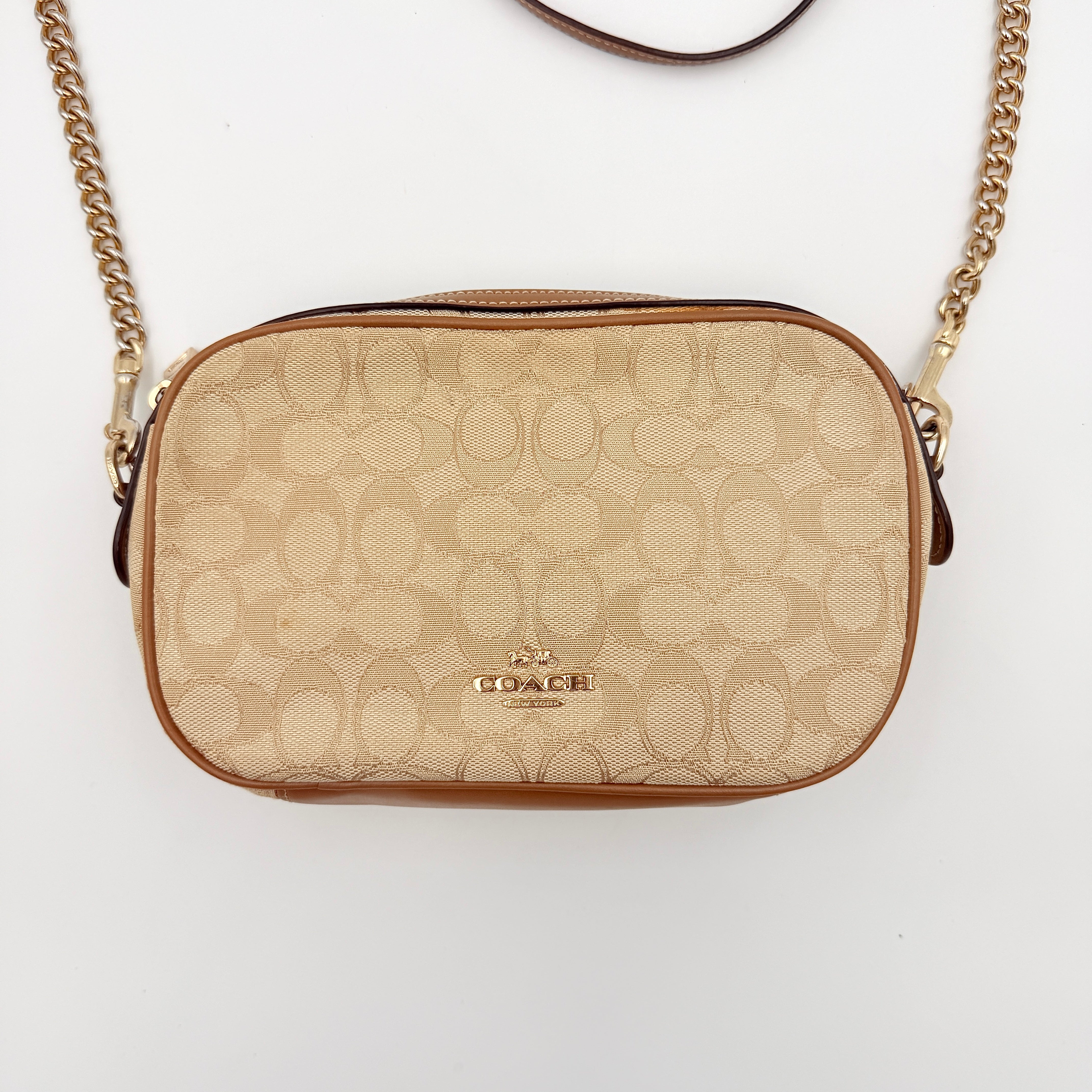 Coach Signature Isla Chain Crossbody Bag in beige and brown jacquard with caramel leather trim and gold-tone chain strap.
