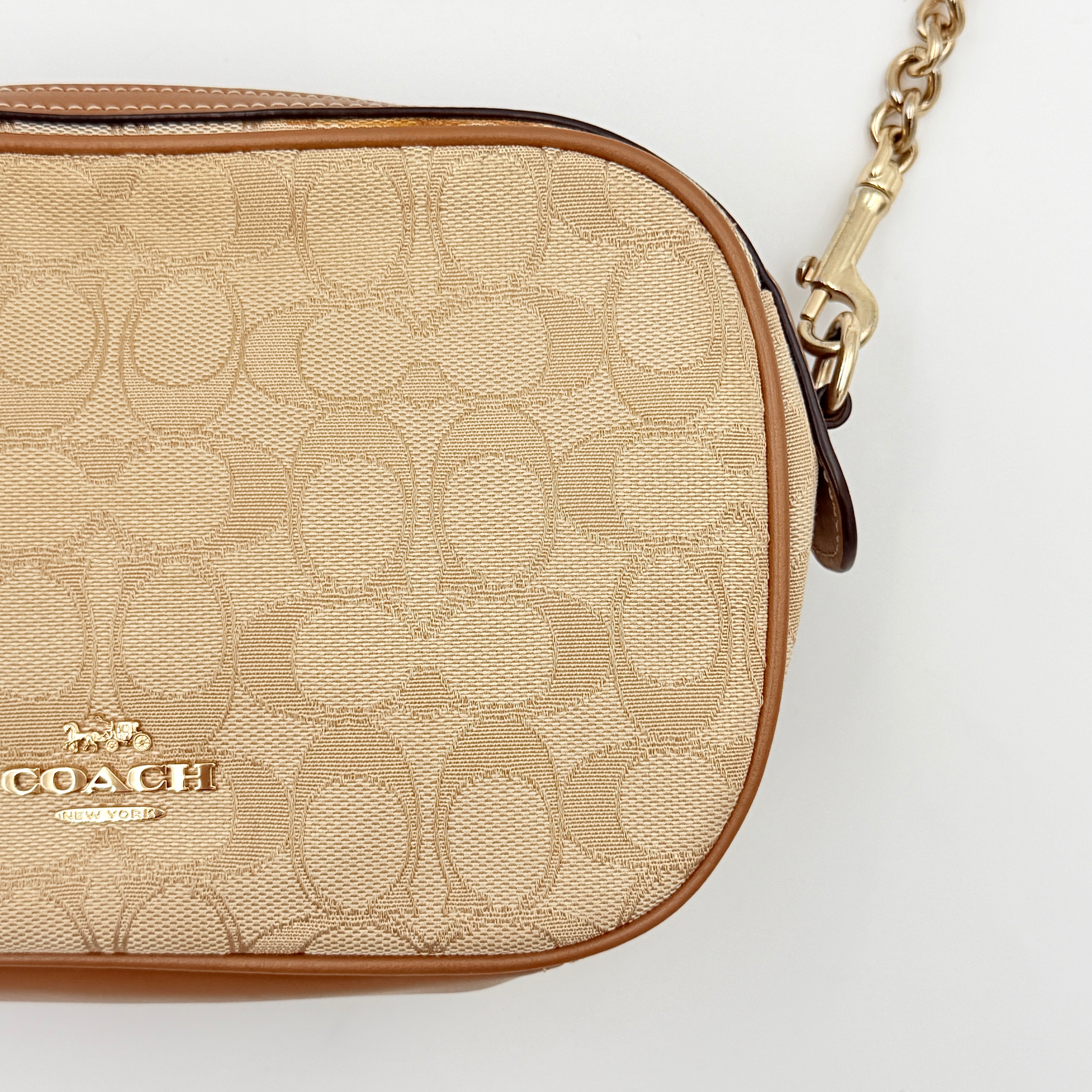 Coach Signature Isla Chain Crossbody Bag in beige and brown jacquard with caramel leather trim and gold-tone chain strap.