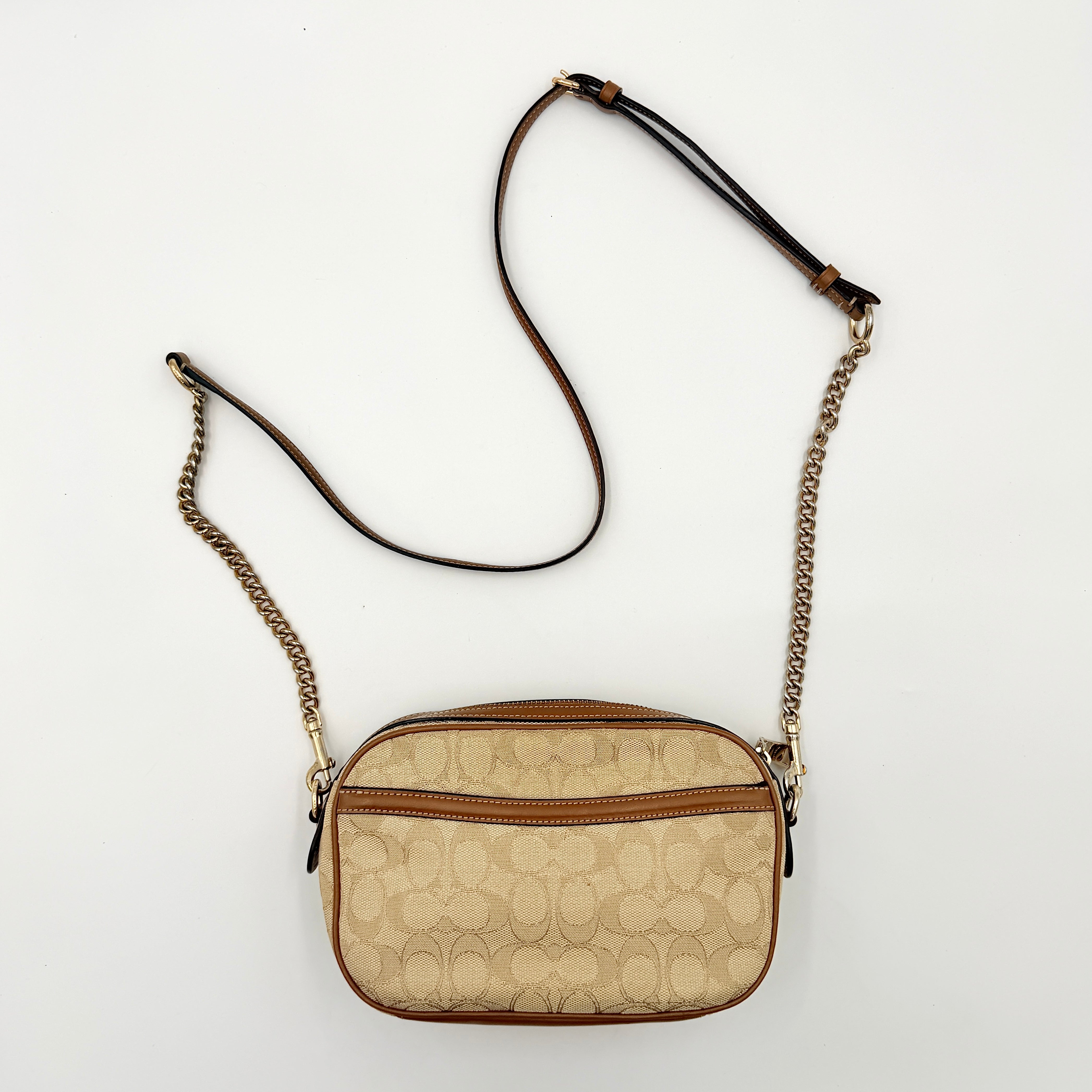Coach Signature Isla Chain Crossbody Bag in beige and brown jacquard with caramel leather trim and gold-tone chain strap.