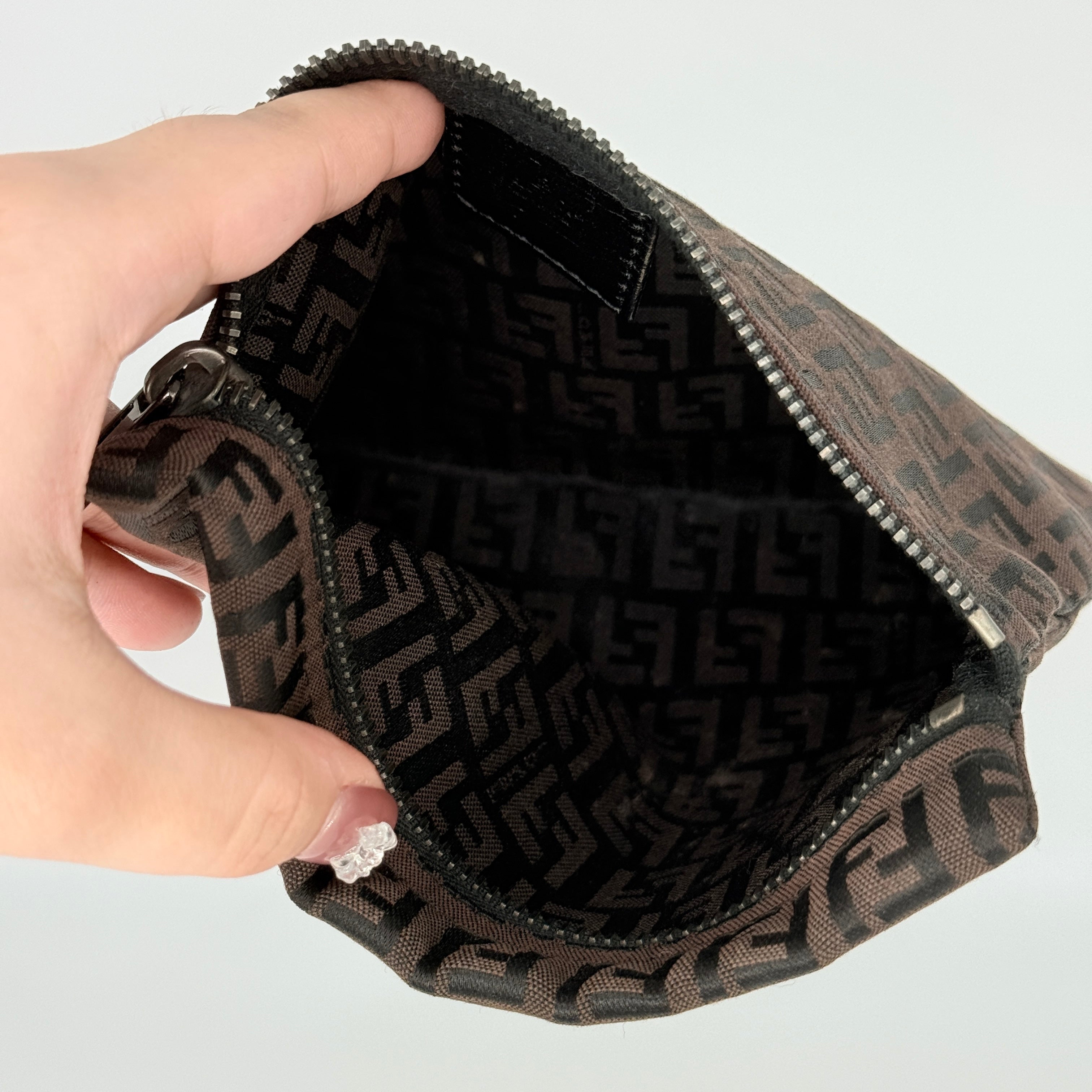 The Fendi FF Zucca Pouch in brown canvas, featuring an all-over FF logo pattern and silver-tone zip closure.