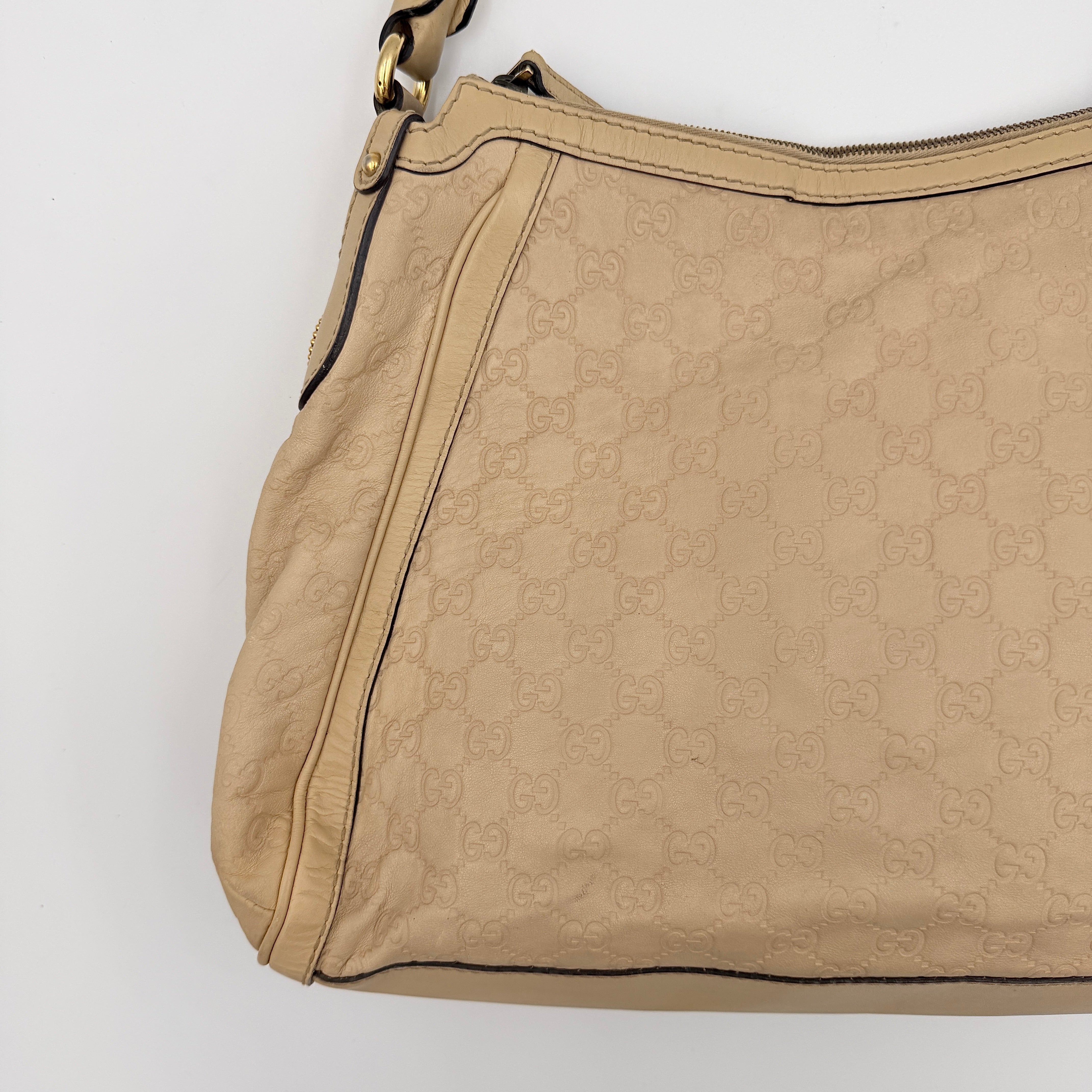 Gucci GG Monogram Guccissima Scarlett Shoulder Bag in beige embossed leather with gold hardware and single top handle.