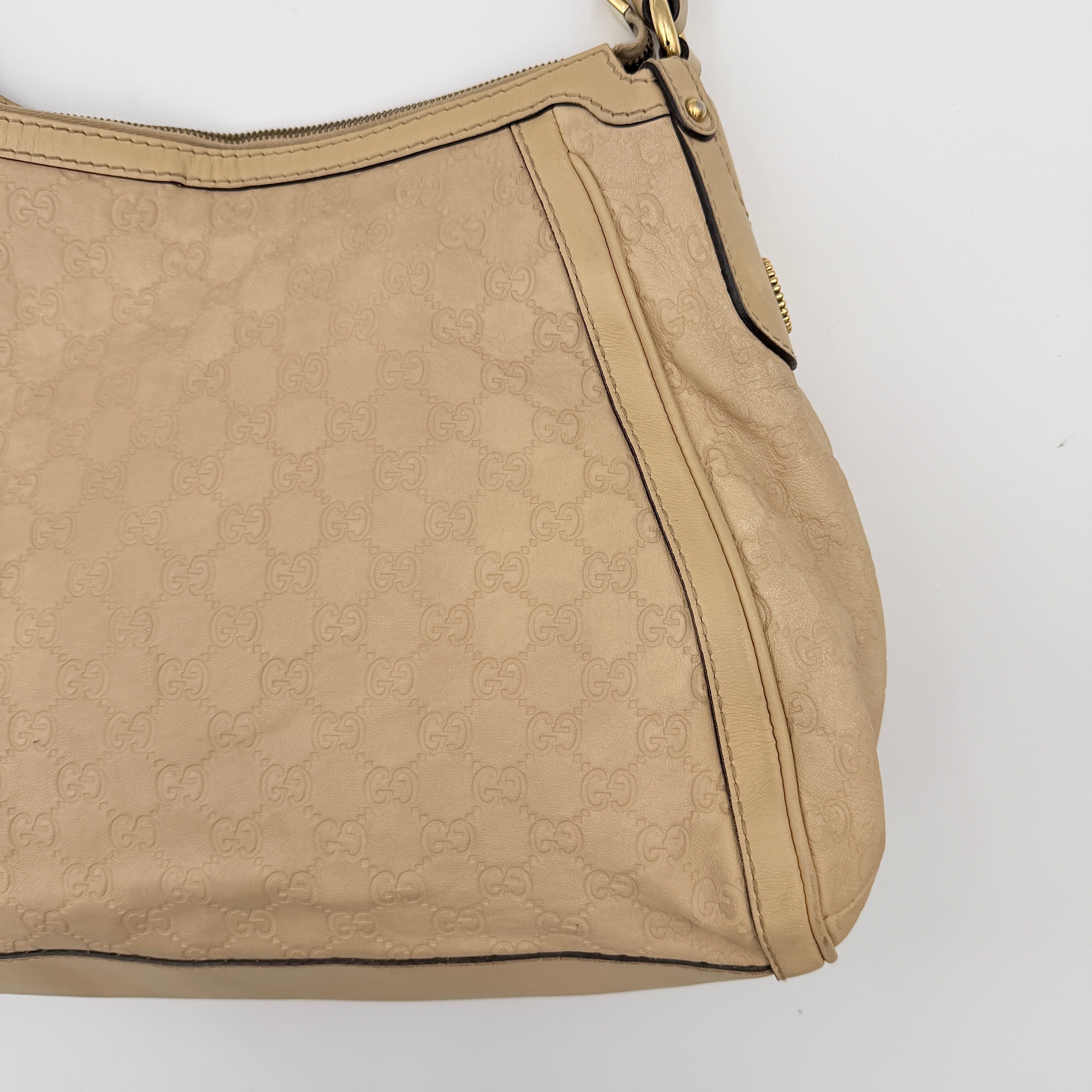 Gucci GG Monogram Guccissima Scarlett Shoulder Bag in beige embossed leather with gold hardware and single top handle.