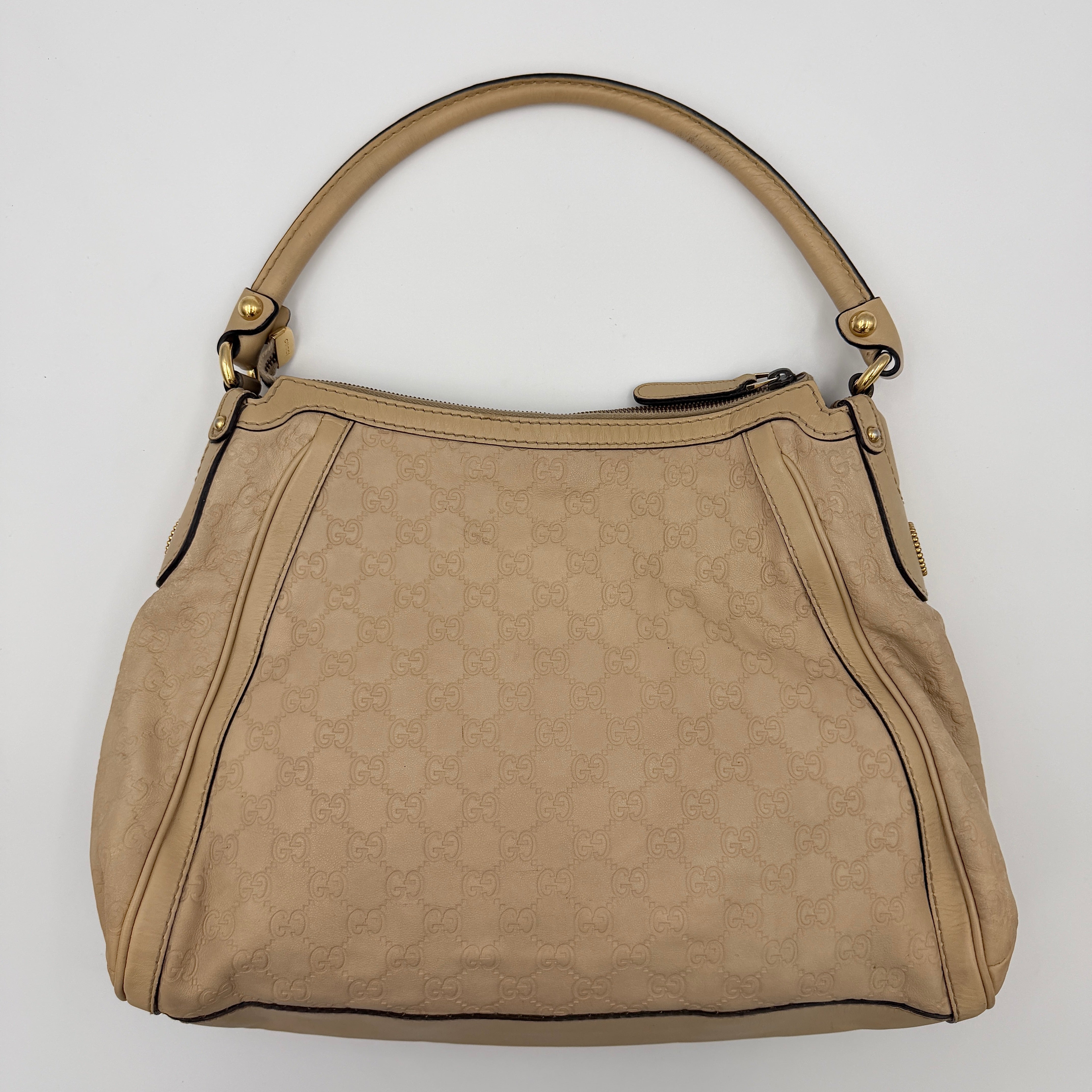Gucci GG Monogram Guccissima Scarlett Shoulder Bag in beige embossed leather with gold hardware and single top handle.