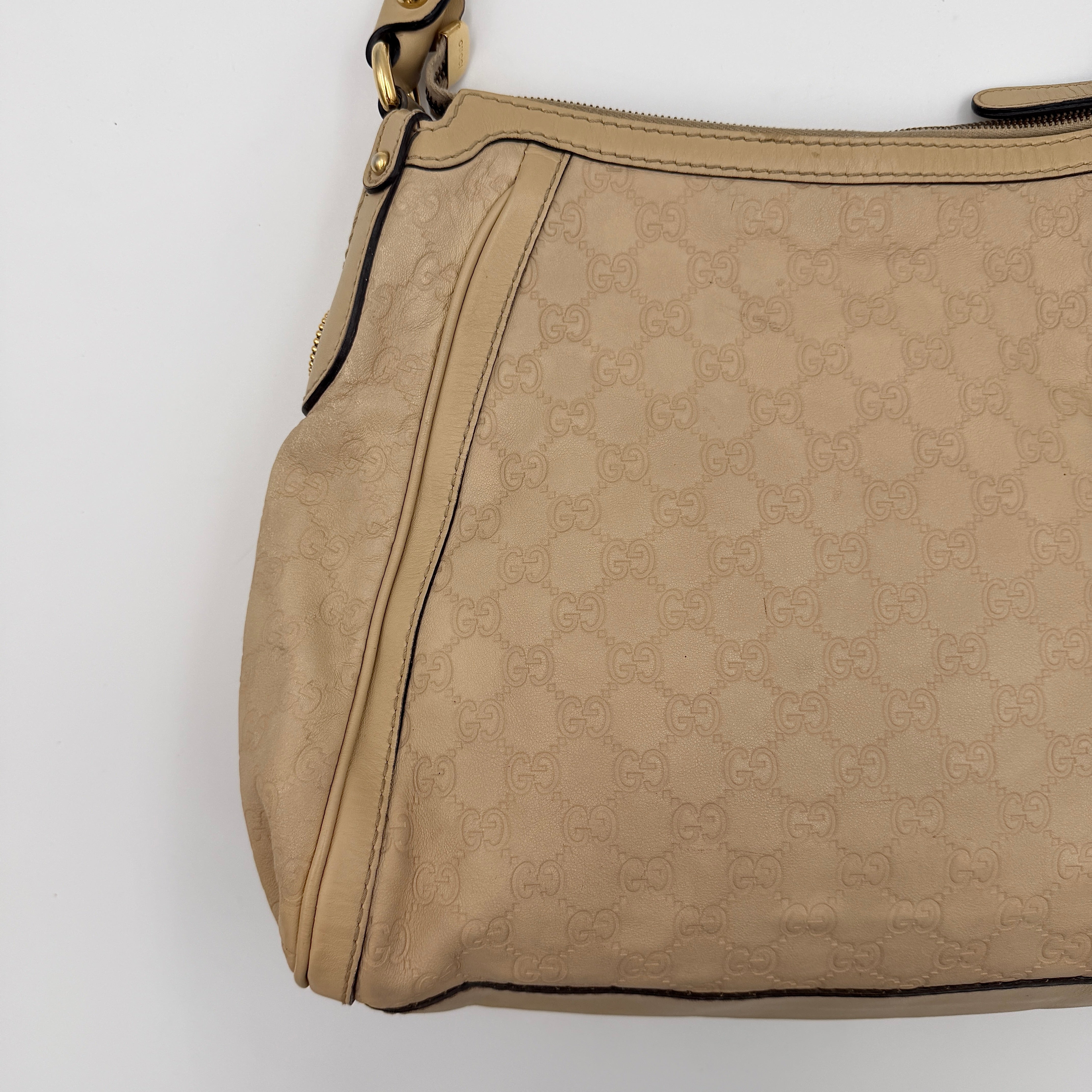Gucci GG Monogram Guccissima Scarlett Shoulder Bag in beige embossed leather with gold hardware and single top handle.