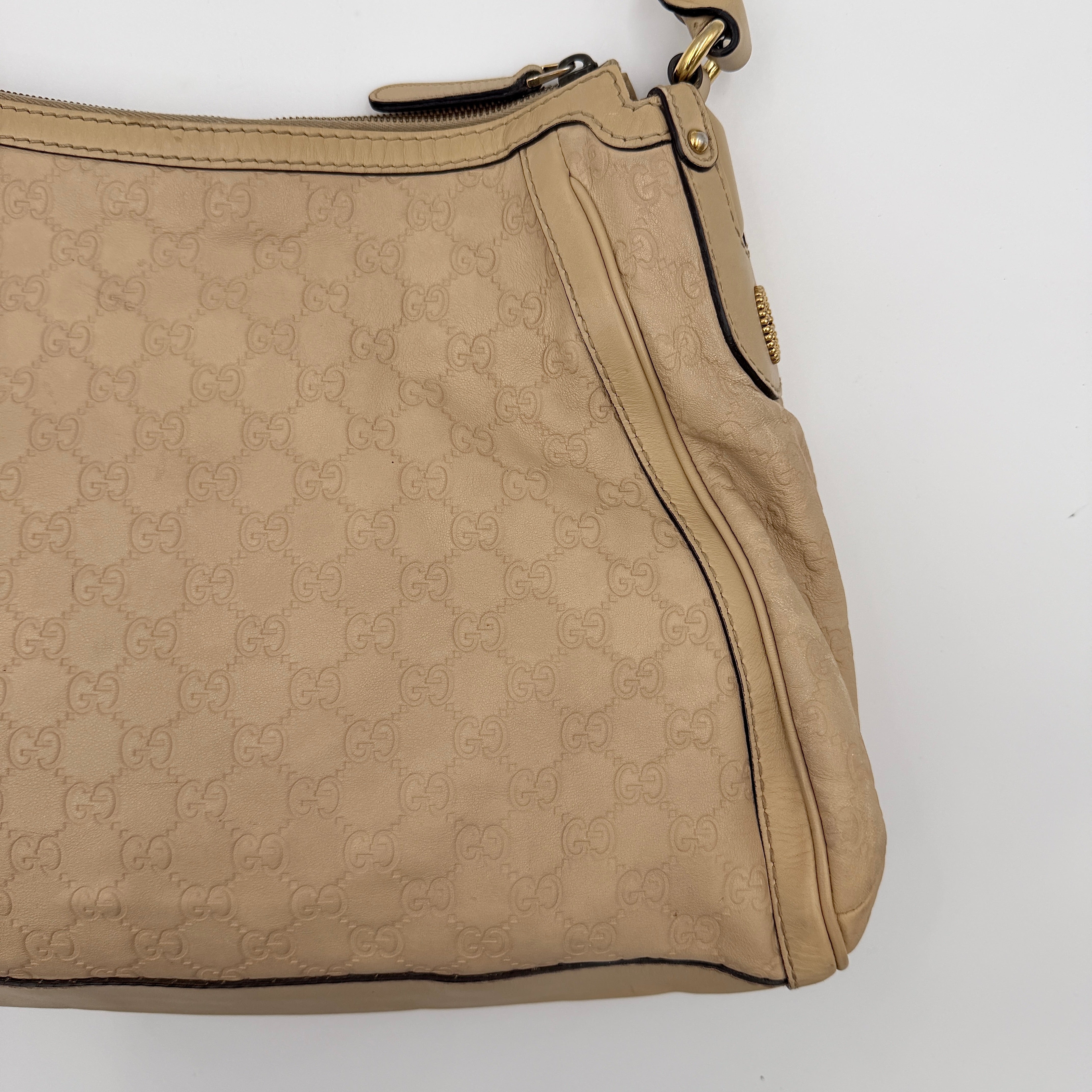 Gucci GG Monogram Guccissima Scarlett Shoulder Bag in beige embossed leather with gold hardware and single top handle.