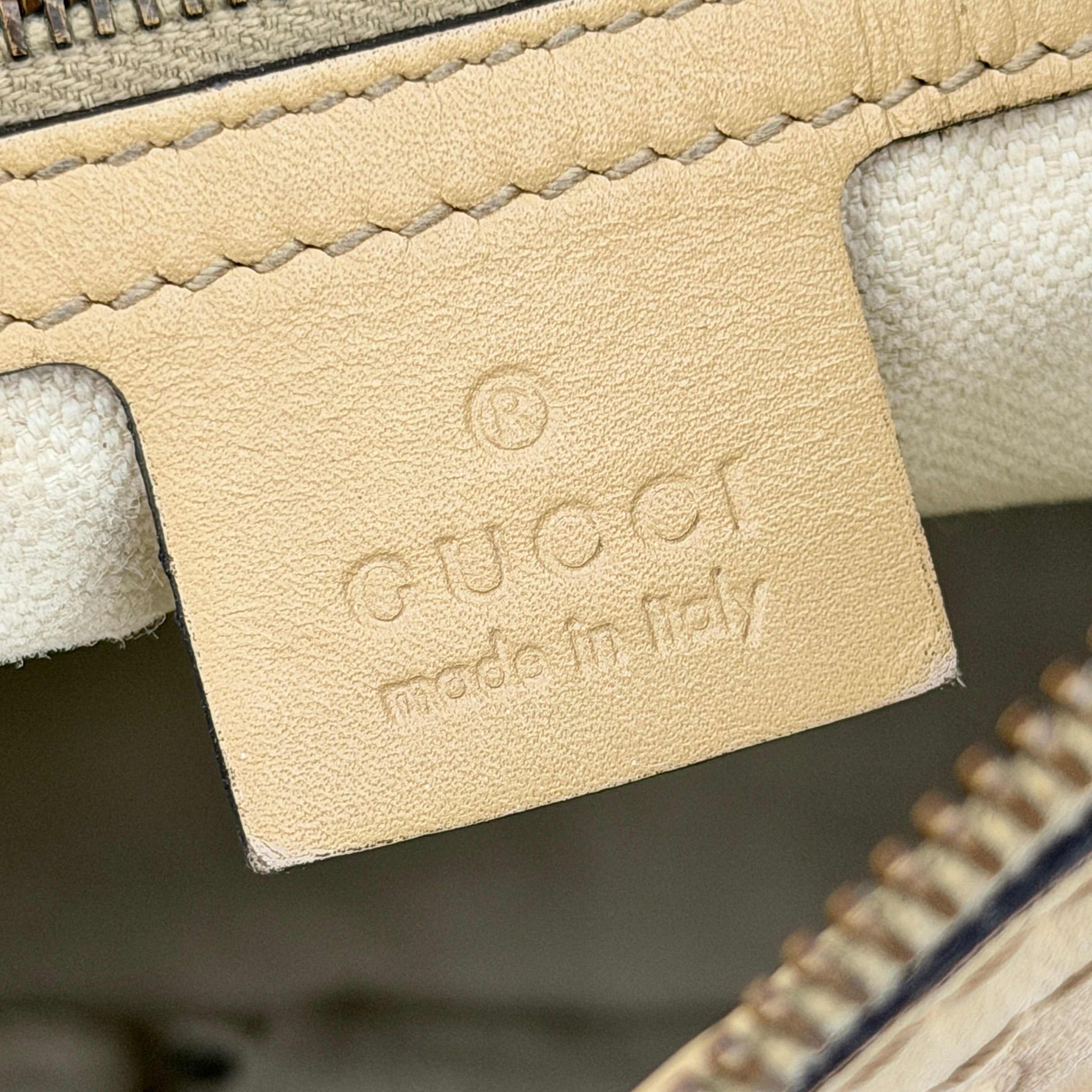 Gucci GG Monogram Guccissima Scarlett Shoulder Bag in beige embossed leather with gold hardware and single top handle.