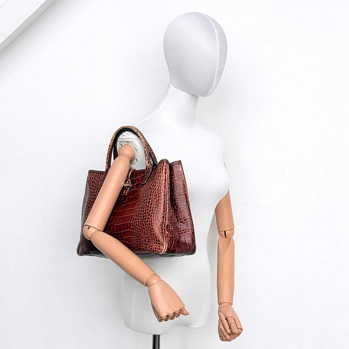 Longchamp Roseau handbag in brown croc-embossed leather with silver-tone bamboo hardware, shown standing against a clean background.