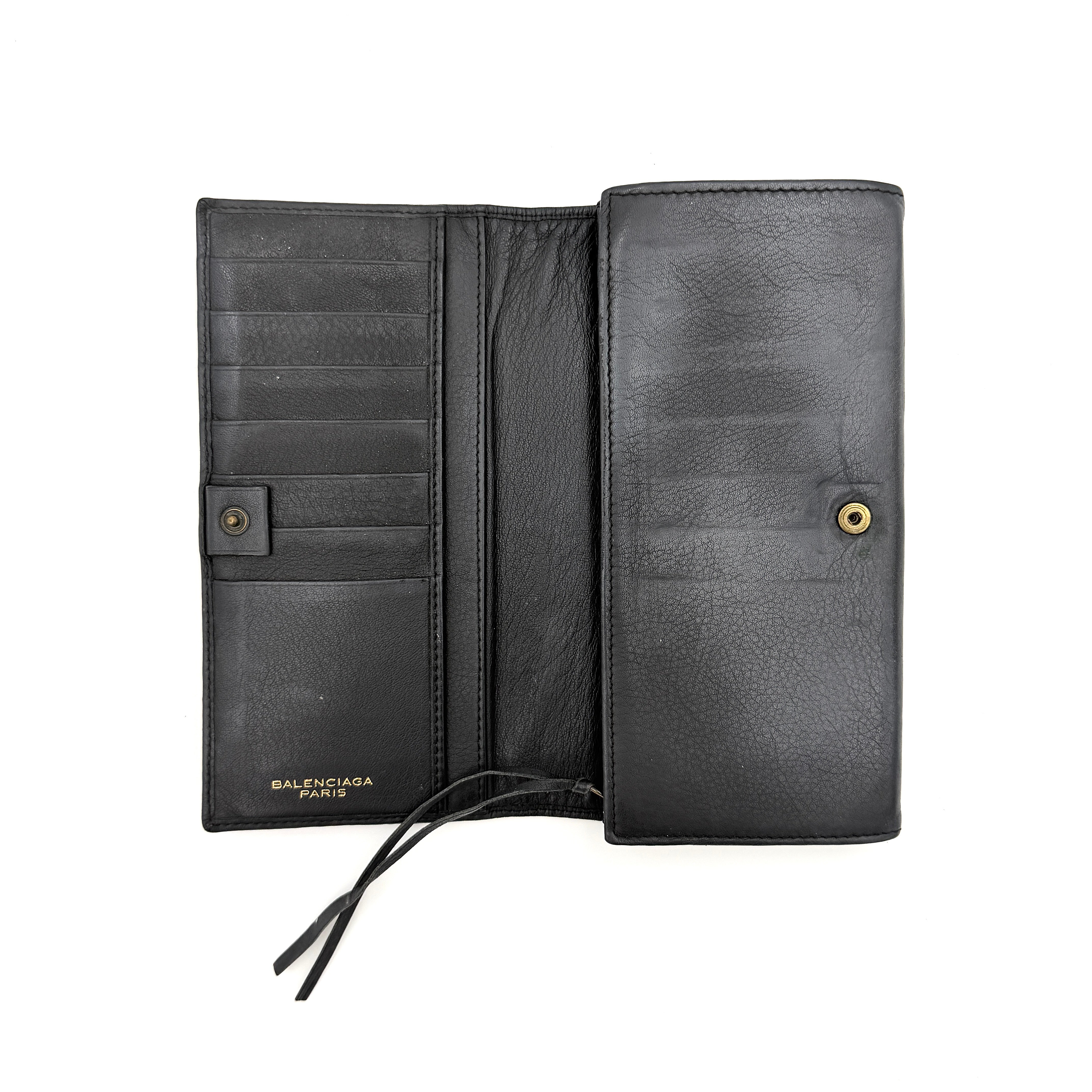 Balenciaga Agneau Leather Wallet in black with signature brass hardware and front zip detail, presented against a white background.