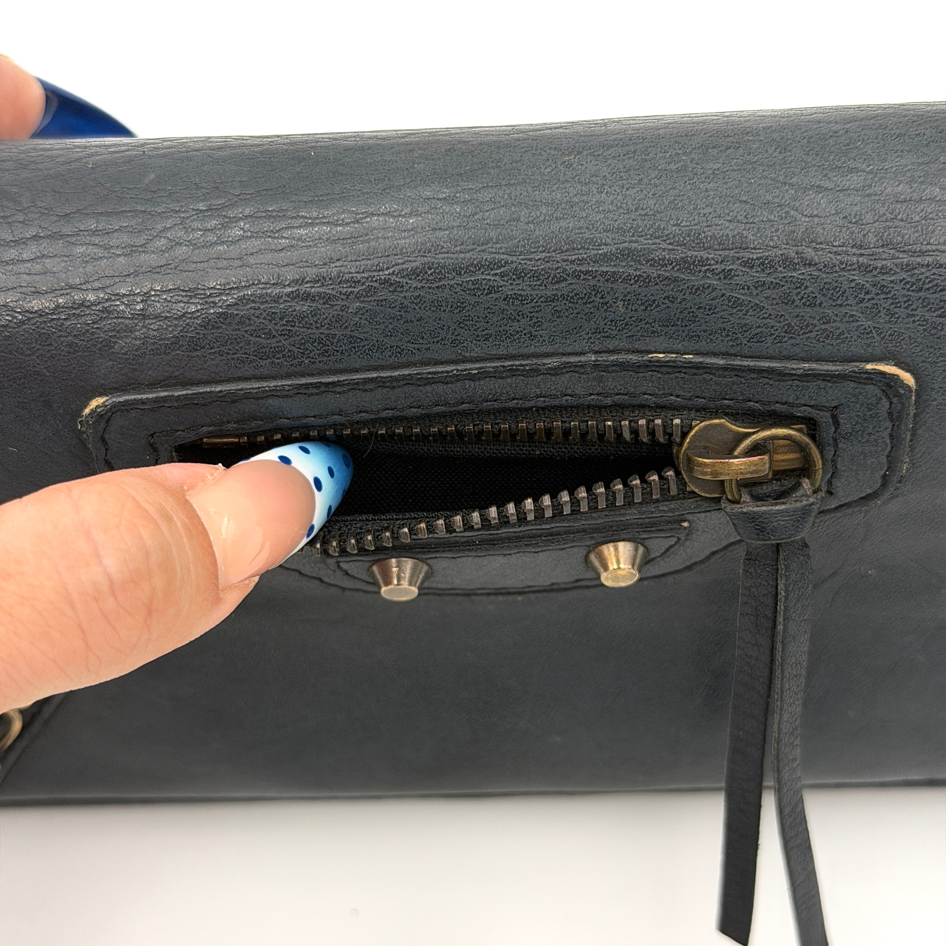 Balenciaga Agneau Leather Wallet in black with signature brass hardware and front zip detail, presented against a white background.