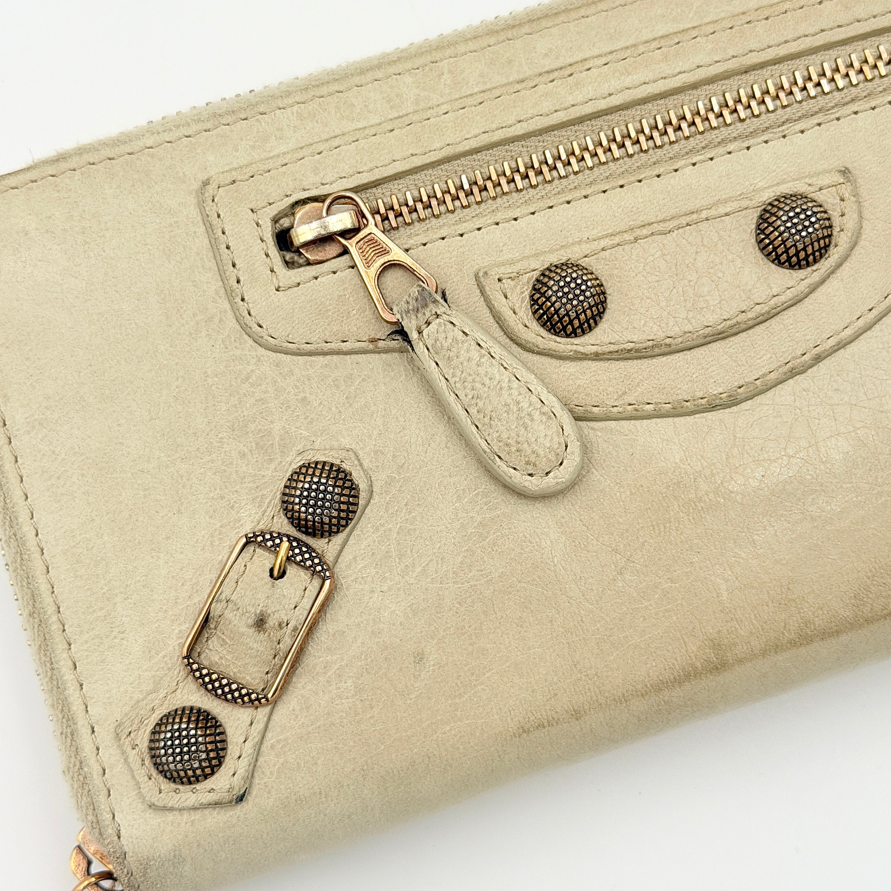 Balenciaga Motorcycle Studded Long Wallet in beige leather with signature studs and front zip pocket, displayed against a clean background.