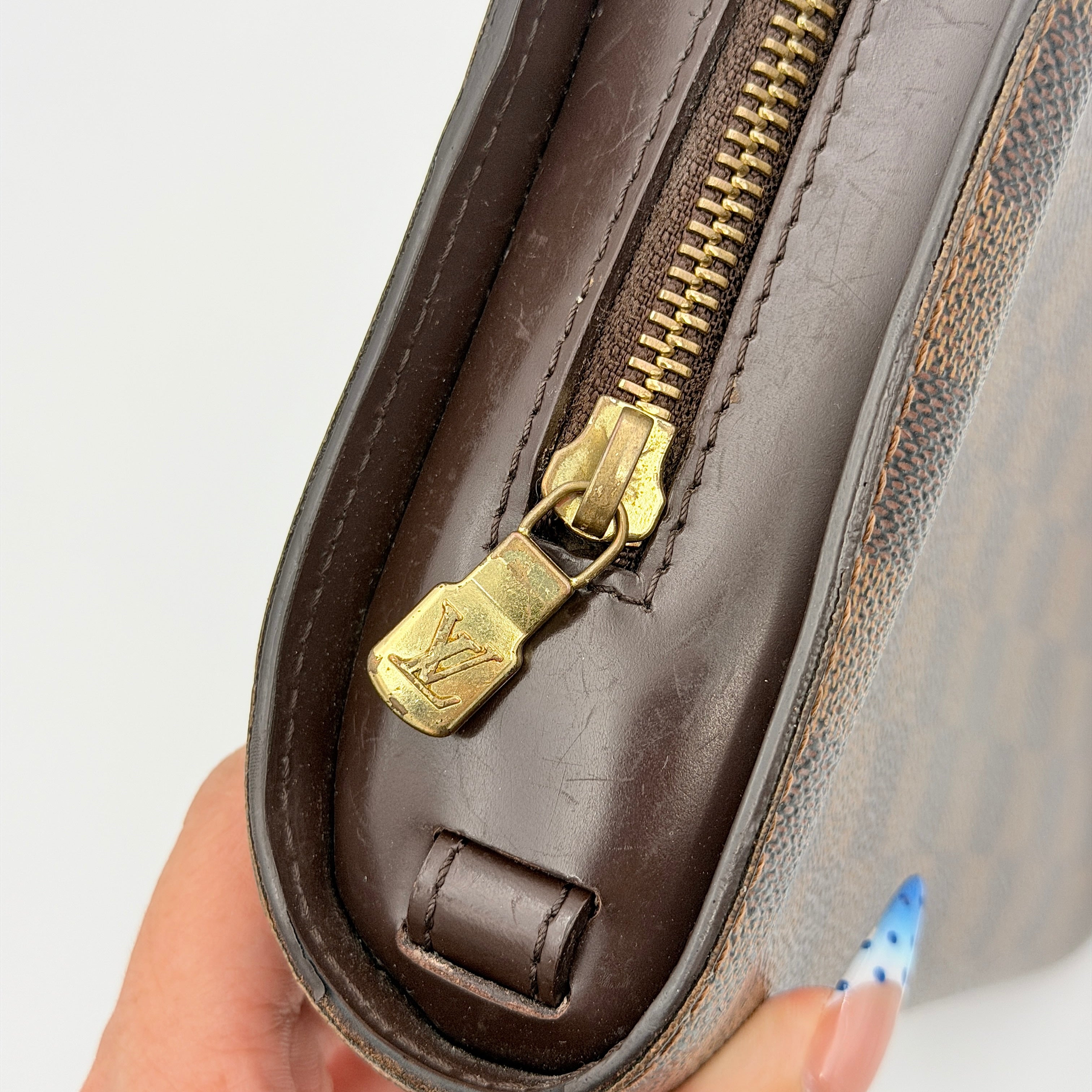 Louis Vuitton Saint Louis Damier Clutch Bag in brown Damier Ebene canvas with chocolate leather trim and gold-tone hardware, photographed on white background.