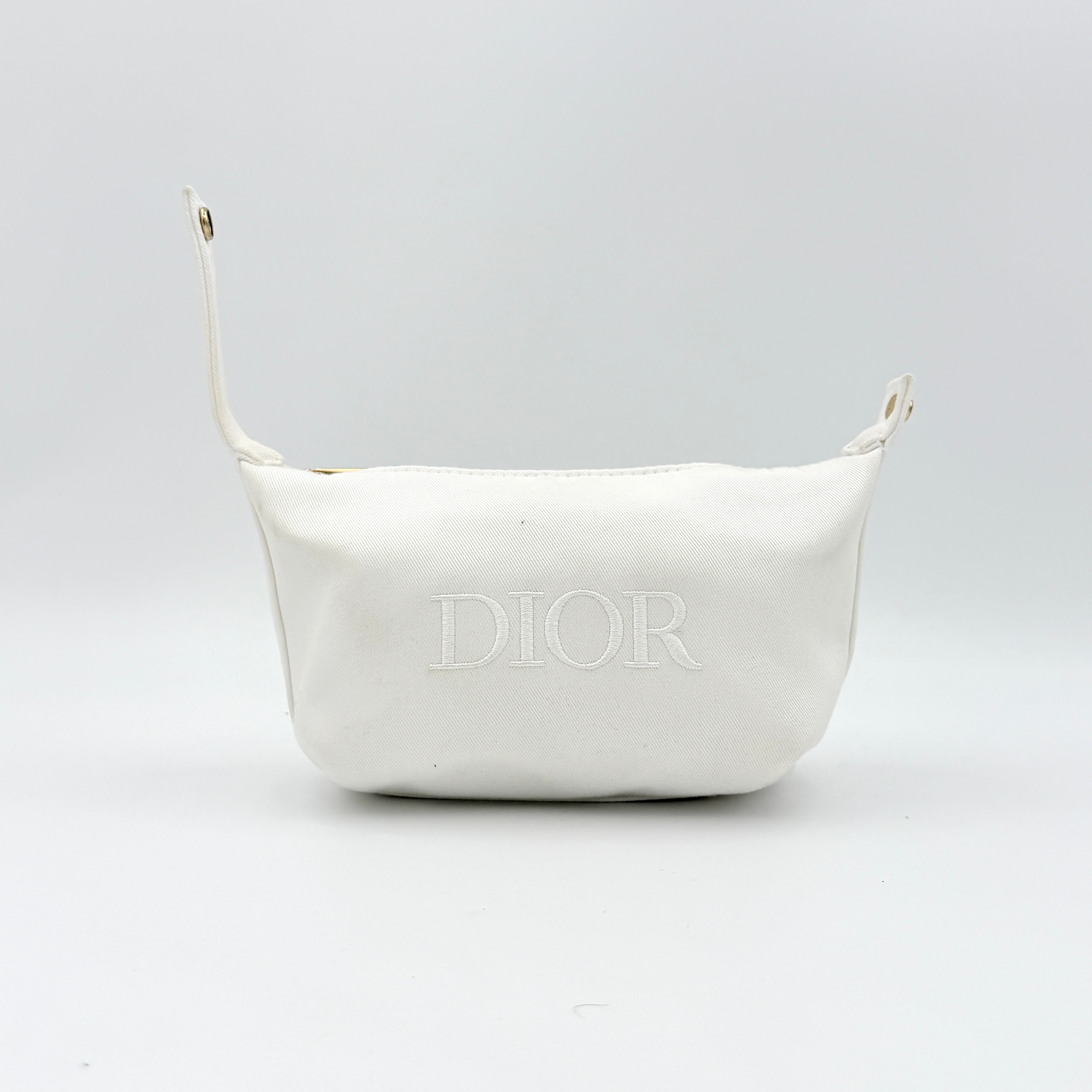 A structured white Dior pouch in twill with tonal logo embroidery and gold-tone zip, displayed against a pristine backdrop.
