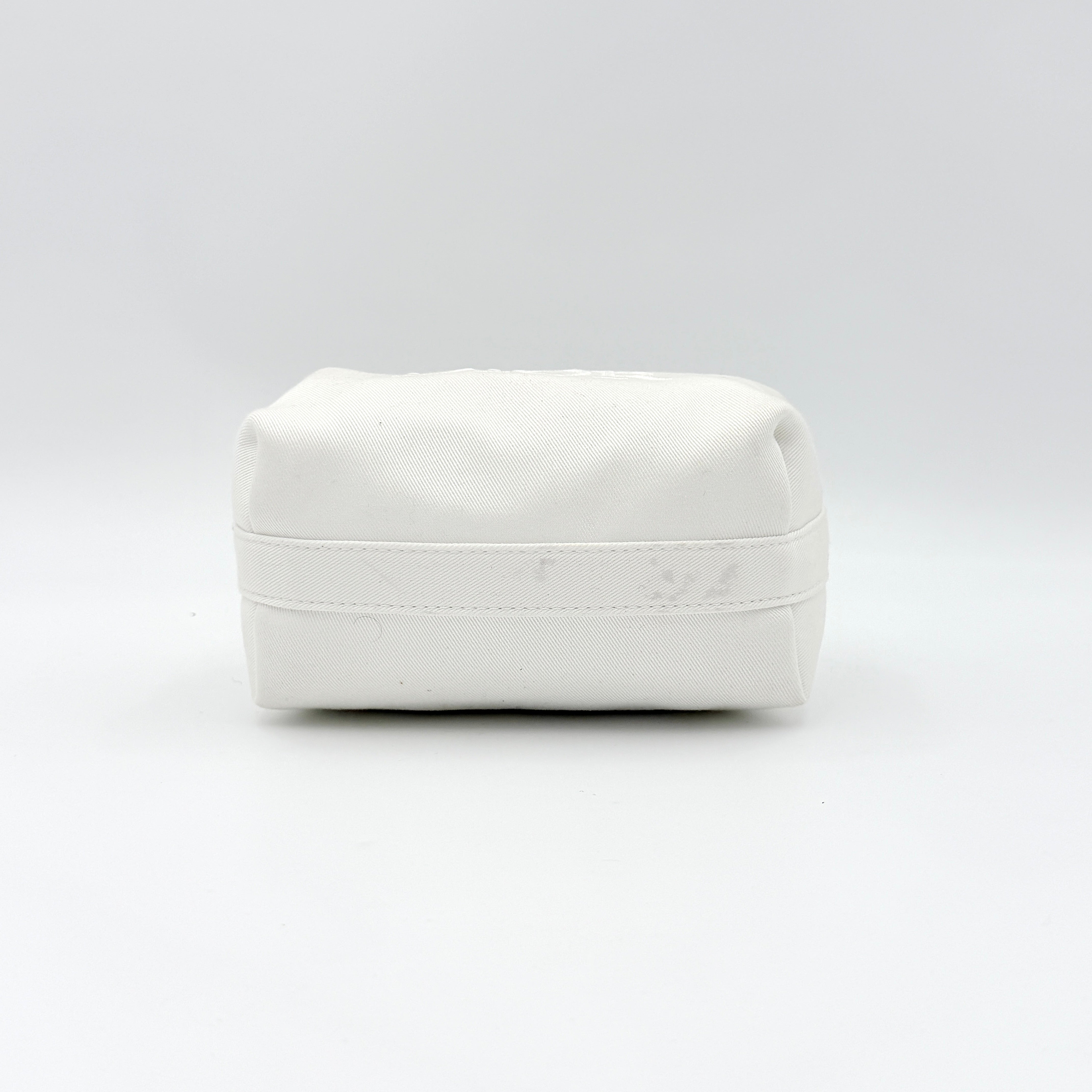 A structured white Dior pouch in twill with tonal logo embroidery and gold-tone zip, displayed against a pristine backdrop.