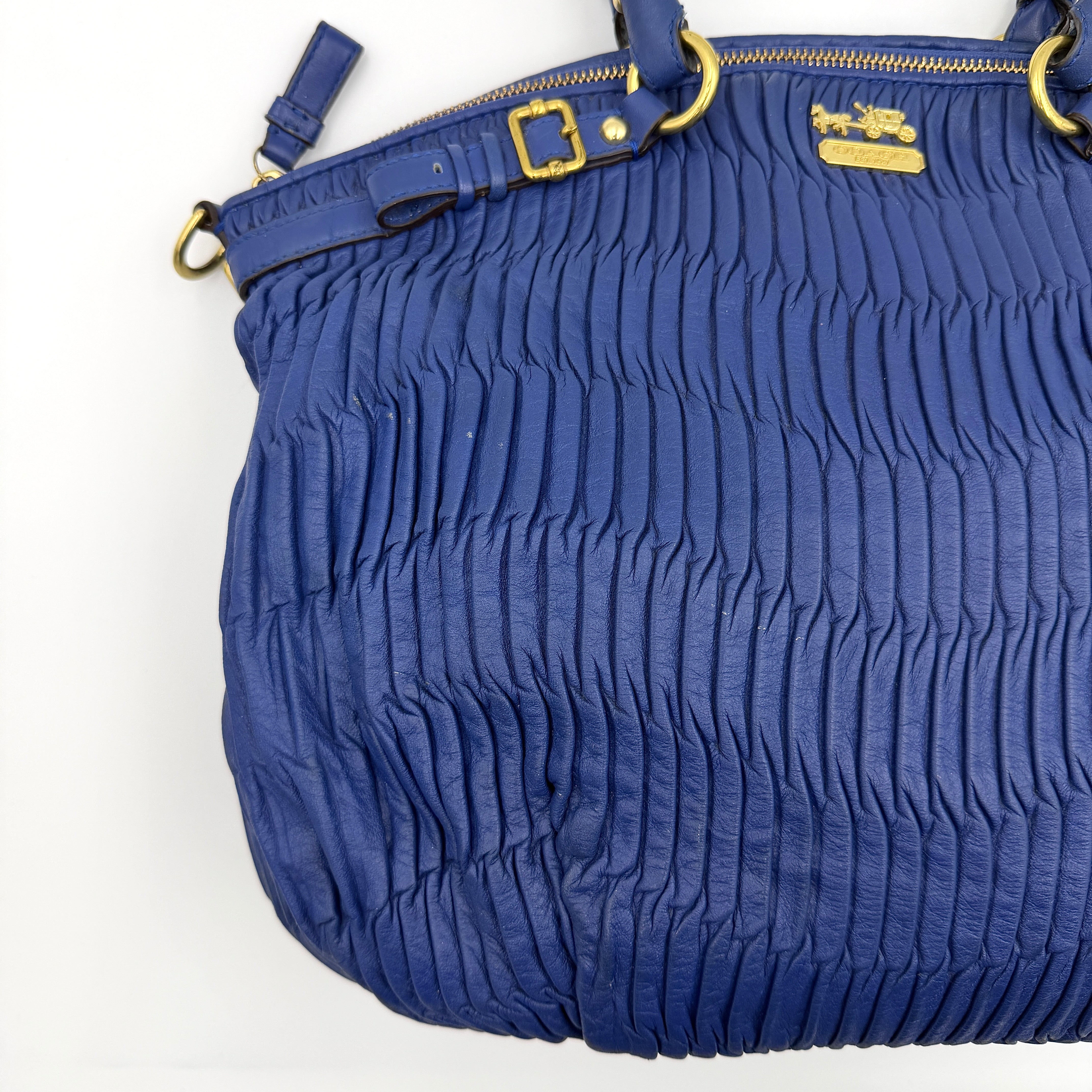 Coach Madison Shoulder Bag in gathered blue leather with gold-tone hardware and removable shoulder strap displayed against a white backdrop.