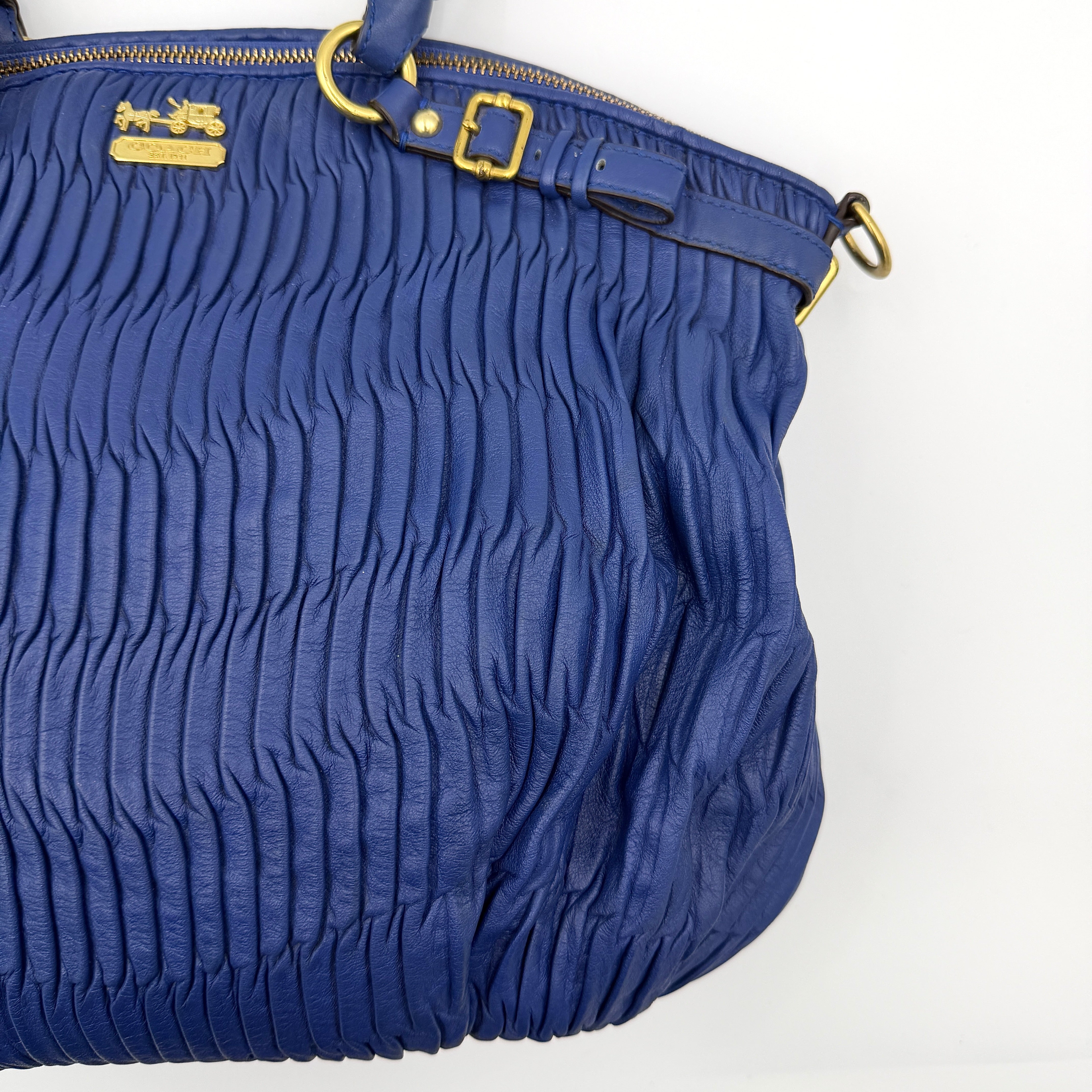 Coach Madison Shoulder Bag in gathered blue leather with gold-tone hardware and removable shoulder strap displayed against a white backdrop.