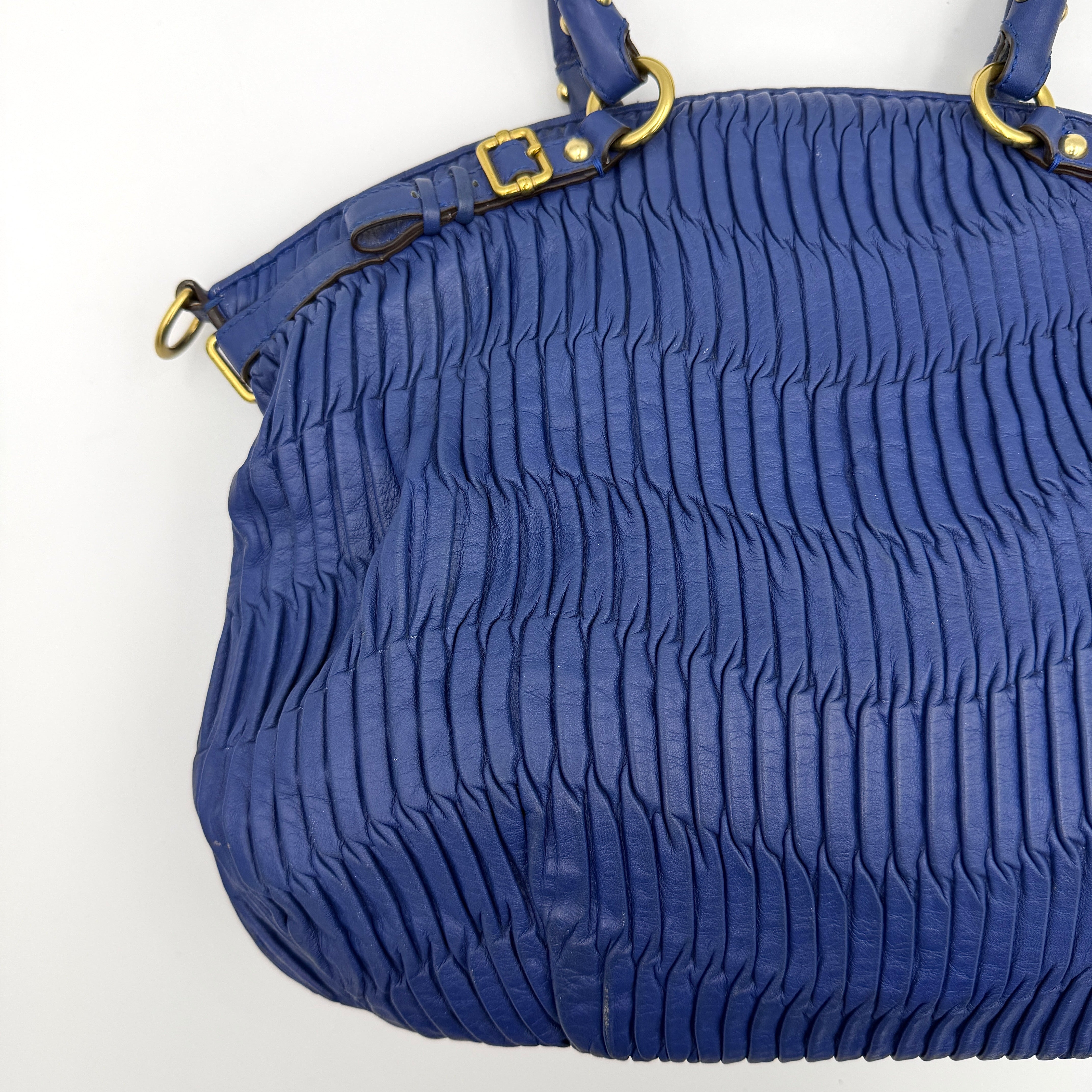 Coach Madison Shoulder Bag in gathered blue leather with gold-tone hardware and removable shoulder strap displayed against a white backdrop.