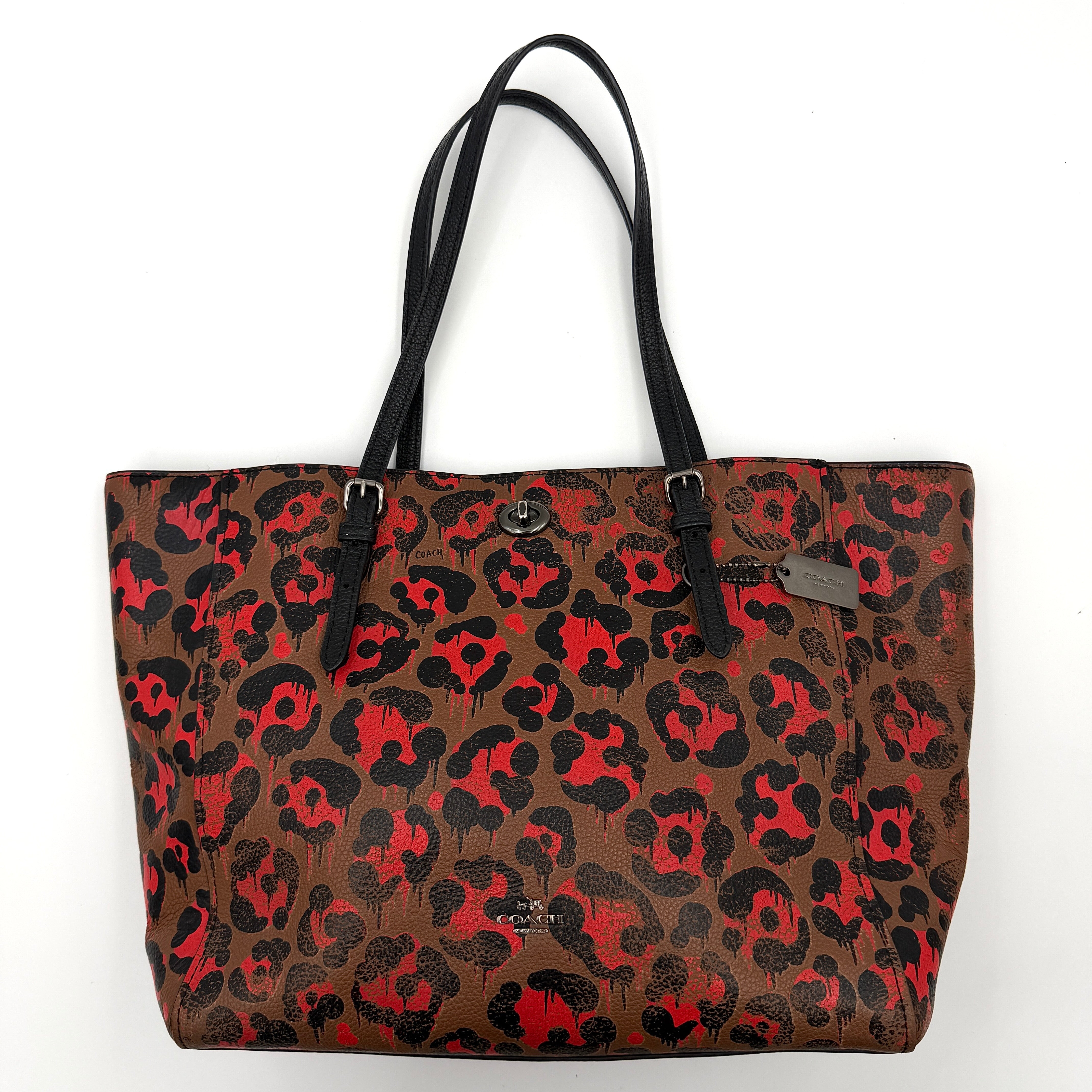 Coach City Tote in brown coated canvas, drenched in a vivid red and black leopard print, with black leather handles and silver hardware details.