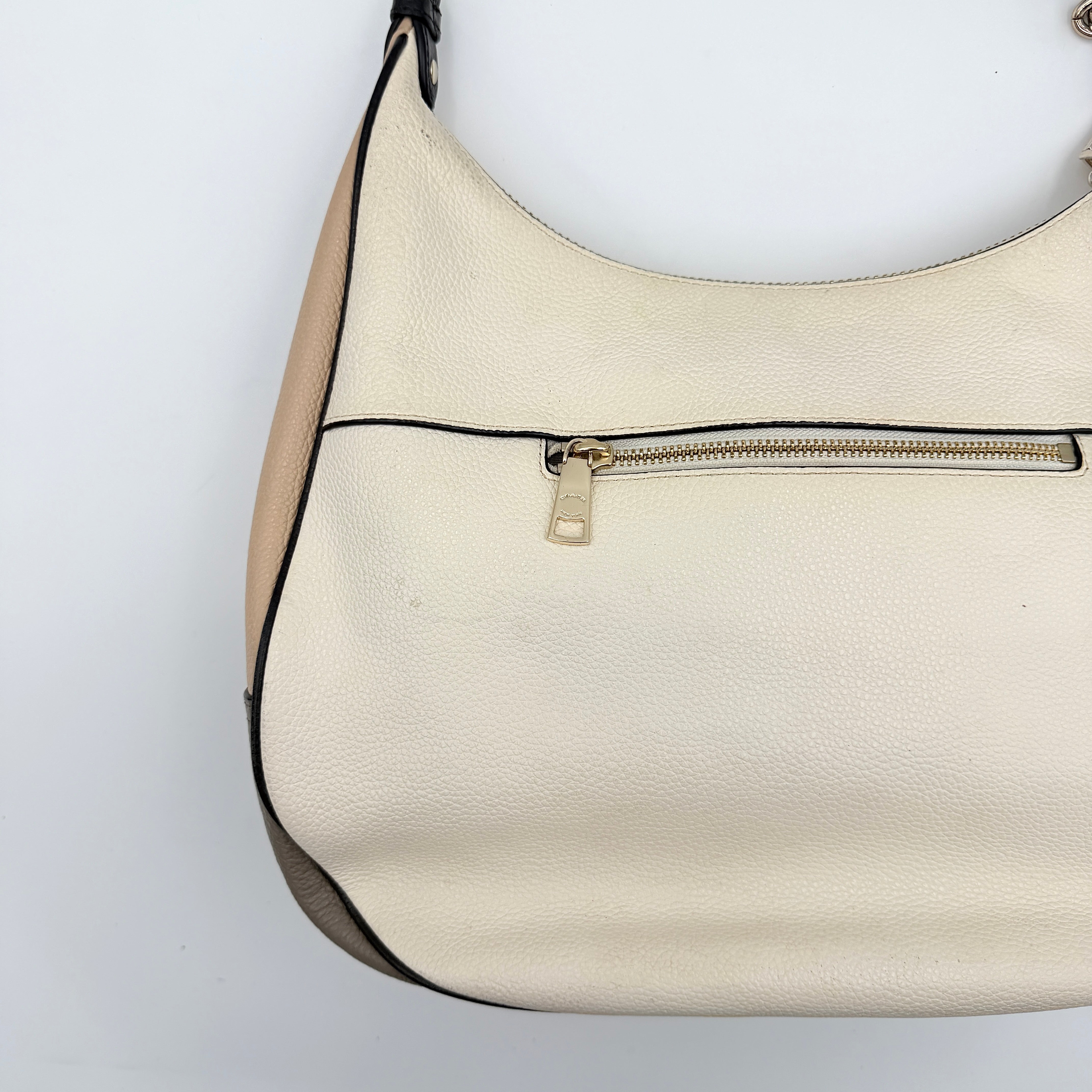 Coach Harley East West Hobo in cream and beige pebbled leather with a sculpted silhouette, black piping, and silver hardware.