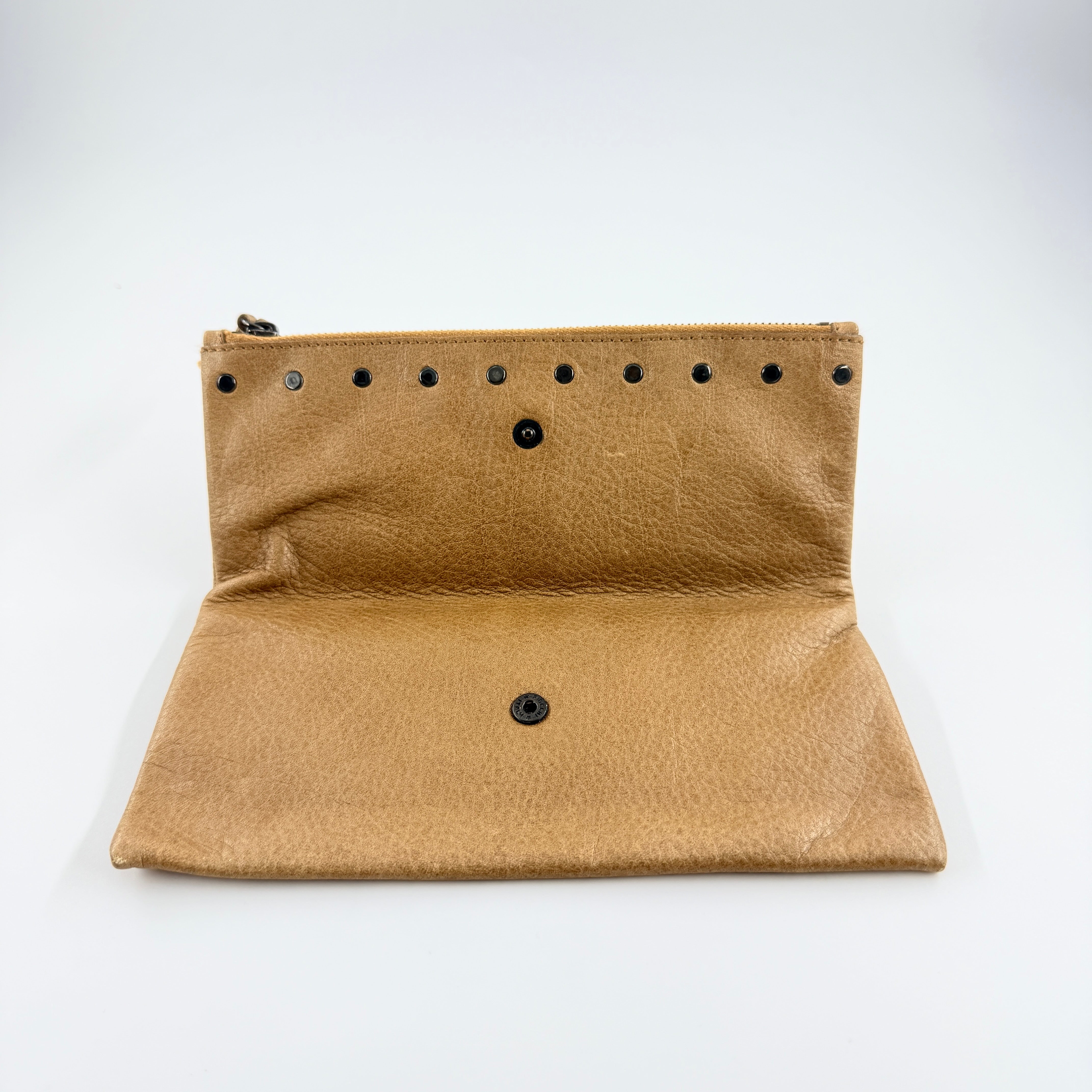 Miu Miu brown textured leather foldover pouch with matte black studs, zip closure, and slim silhouette.
