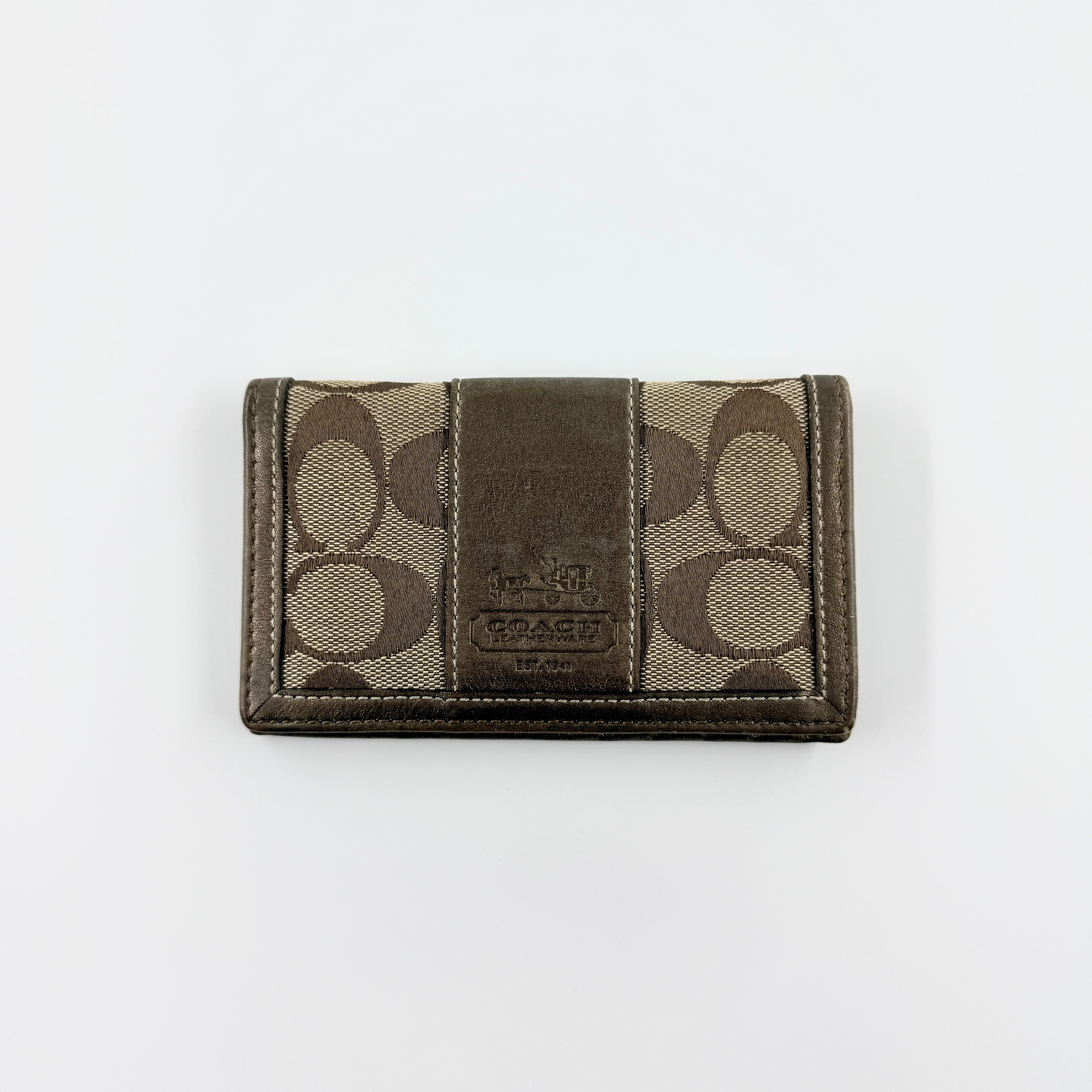 Coach Signature Stripe Snap Wallet in brown jacquard canvas with leather trim and embossed logo, shown against a white background.