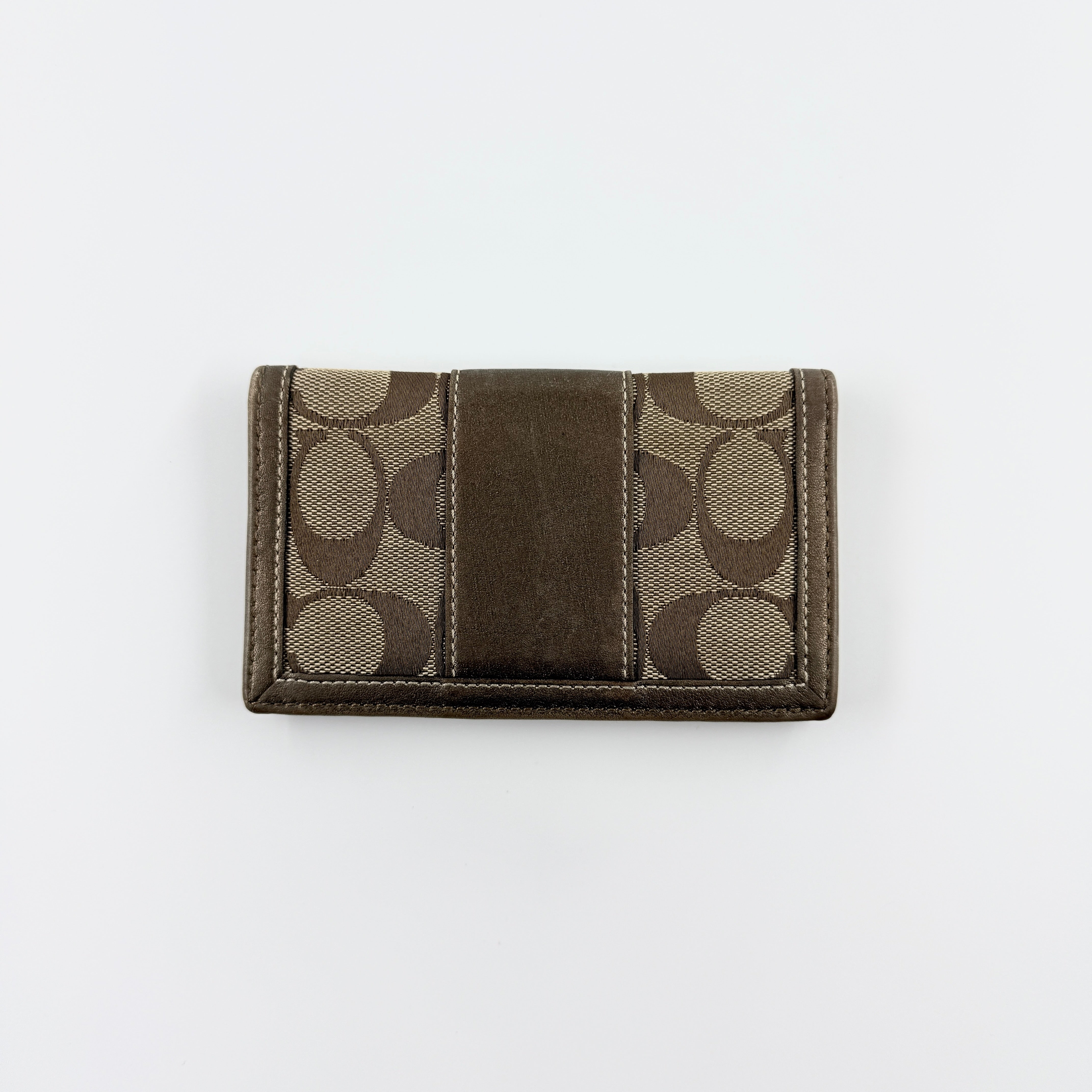 Coach Signature Stripe Snap Wallet in brown jacquard canvas with leather trim and embossed logo, shown against a white background.