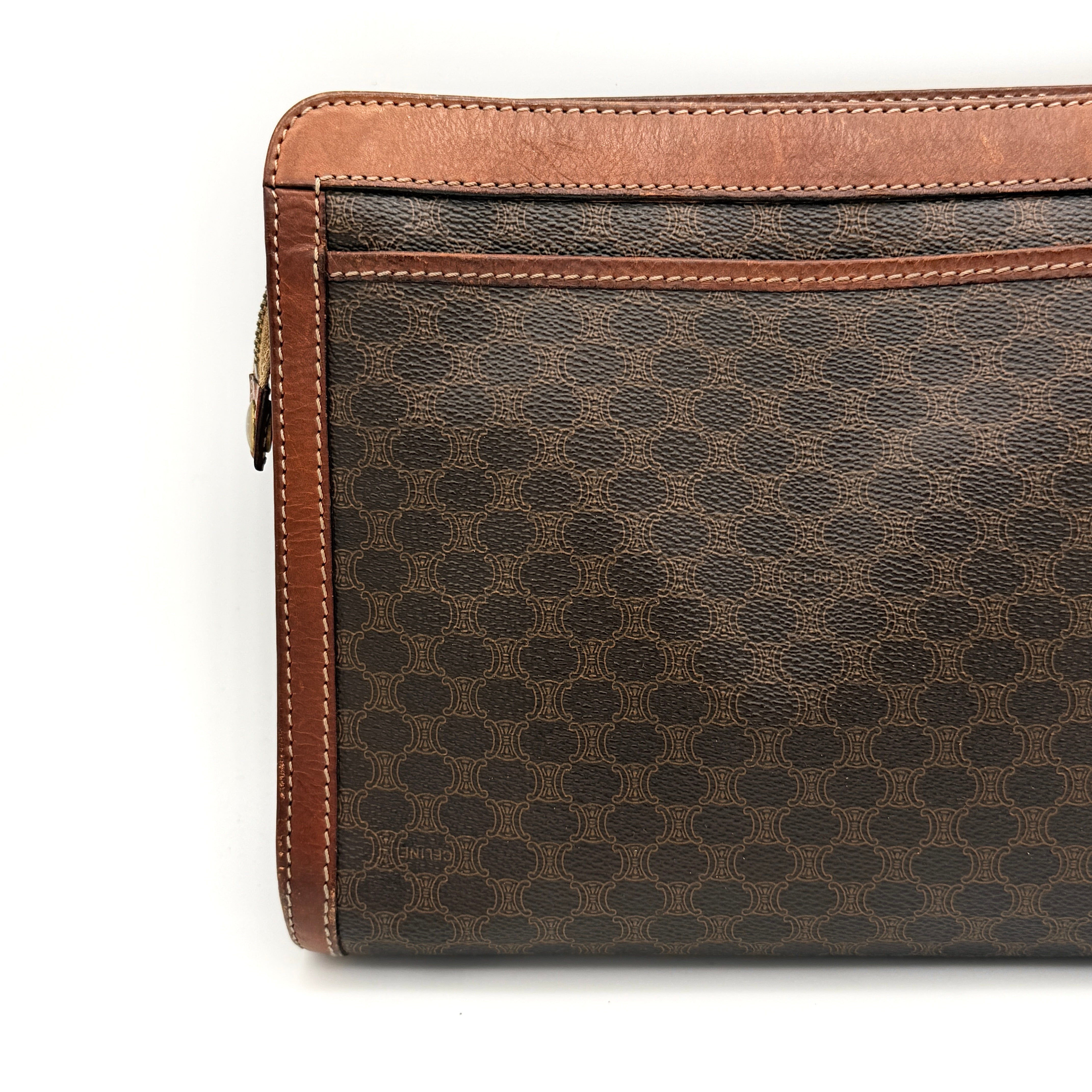 Front view of the Celine Triomphe Macadam clutch bag in brown canvas with tan leather trim and zip pocket.