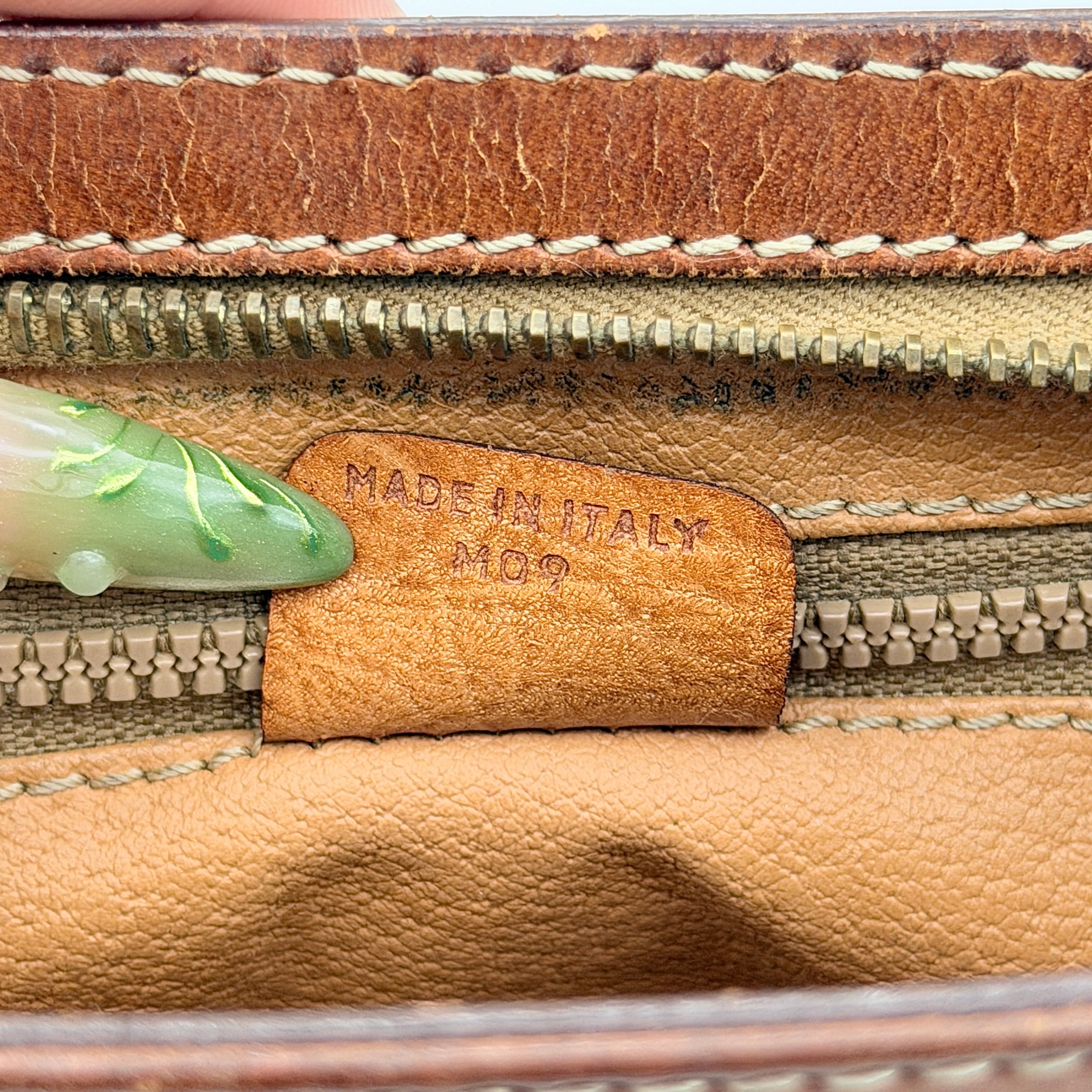 Front view of the Celine Triomphe Macadam clutch bag in brown canvas with tan leather trim and zip pocket.