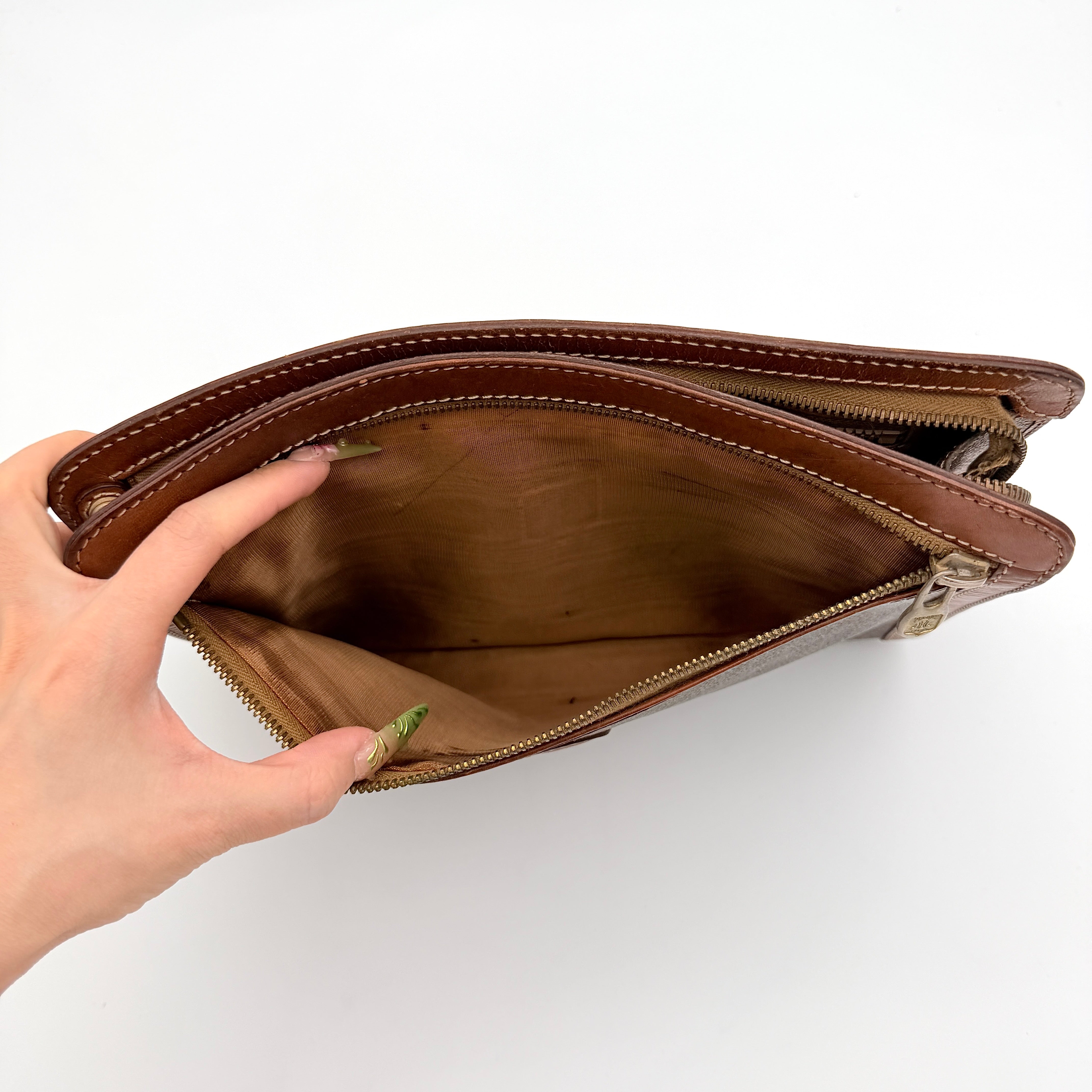 Front view of the Celine Triomphe Macadam clutch bag in brown canvas with tan leather trim and zip pocket.