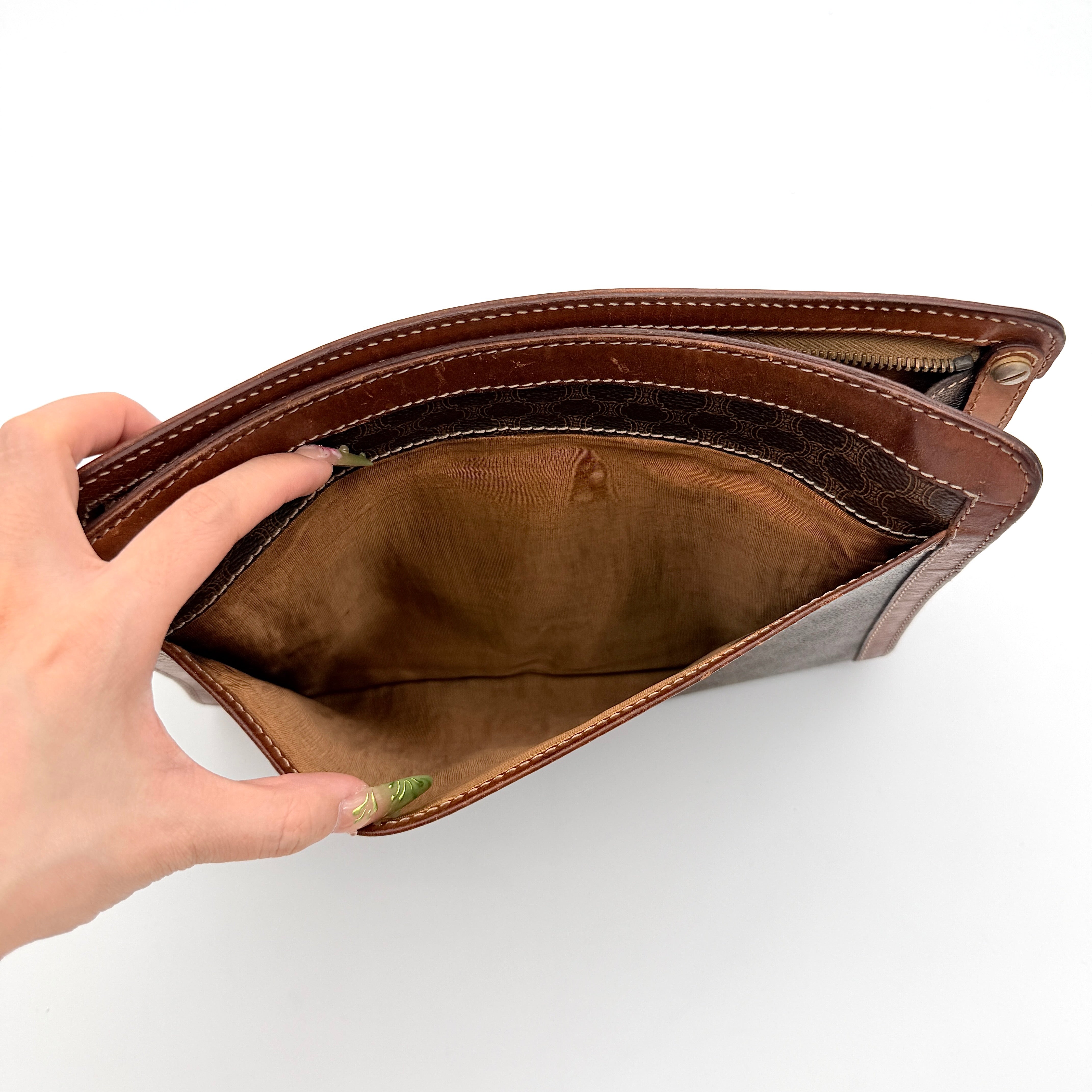 Front view of the Celine Triomphe Macadam clutch bag in brown canvas with tan leather trim and zip pocket.
