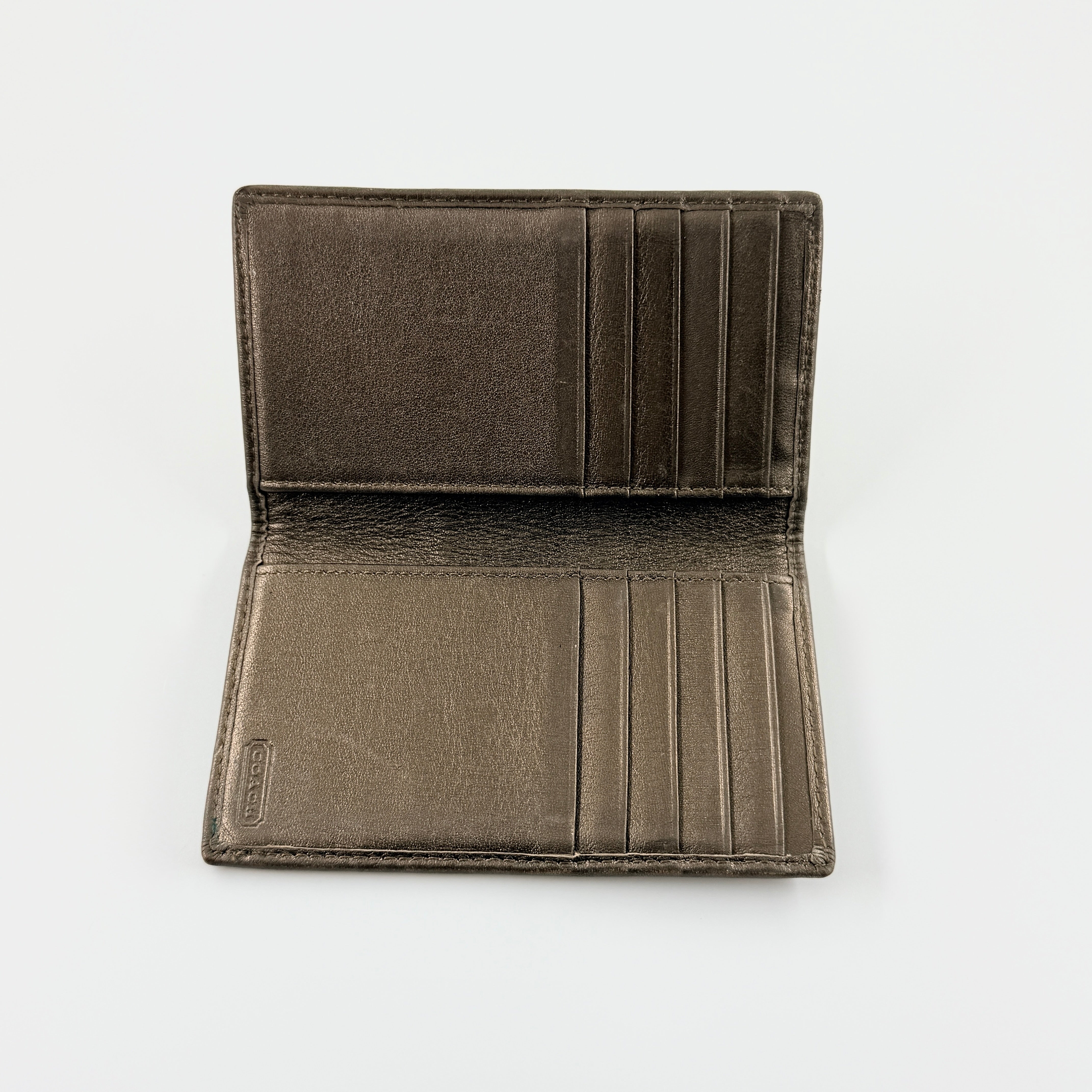 Coach Signature Stripe Snap Wallet in brown jacquard canvas with leather trim and embossed logo, shown against a white background.