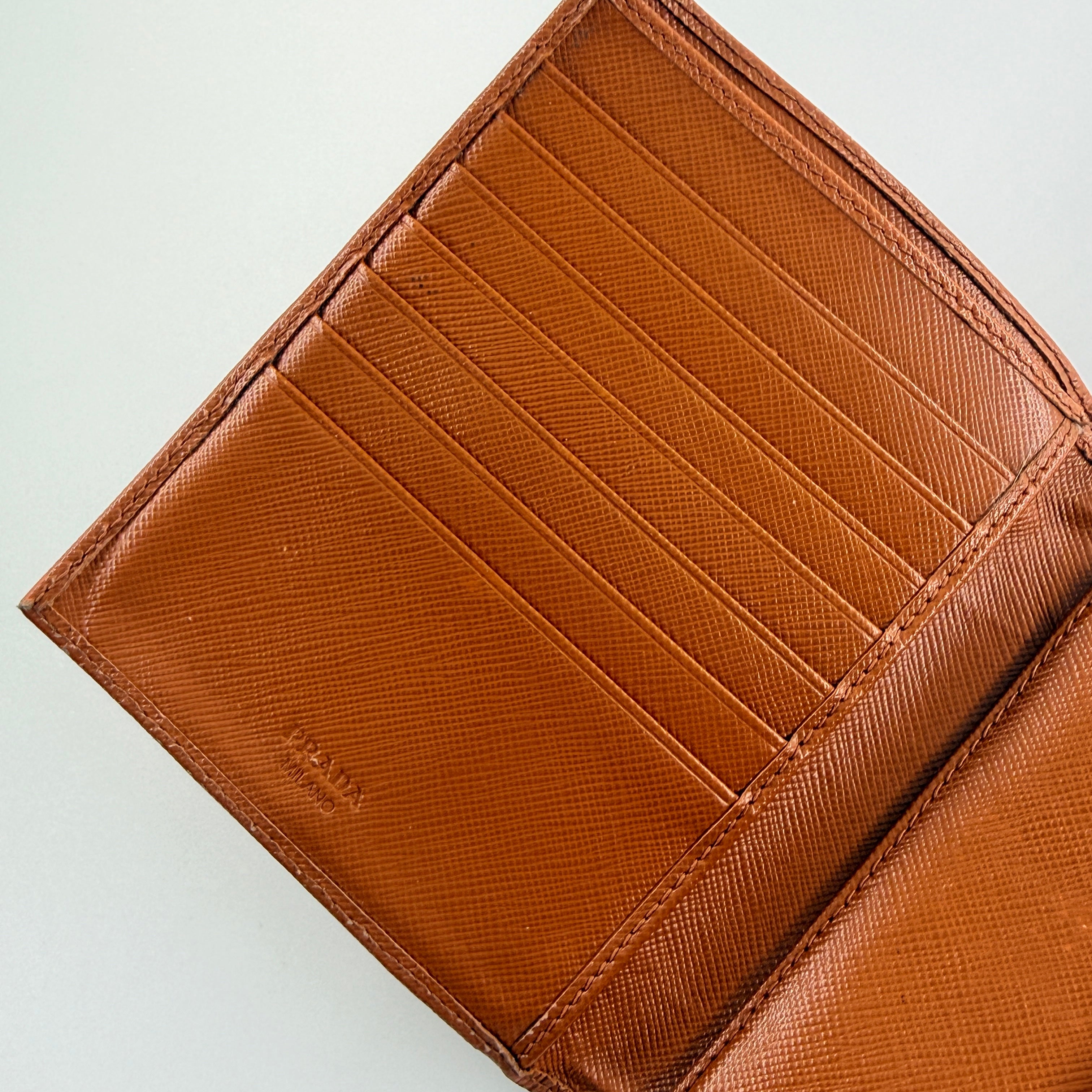 Prada Saffiano Leather Trifold Wallet in brown leather with gold-tone logo, showcasing its structured flap and crosshatch texture.