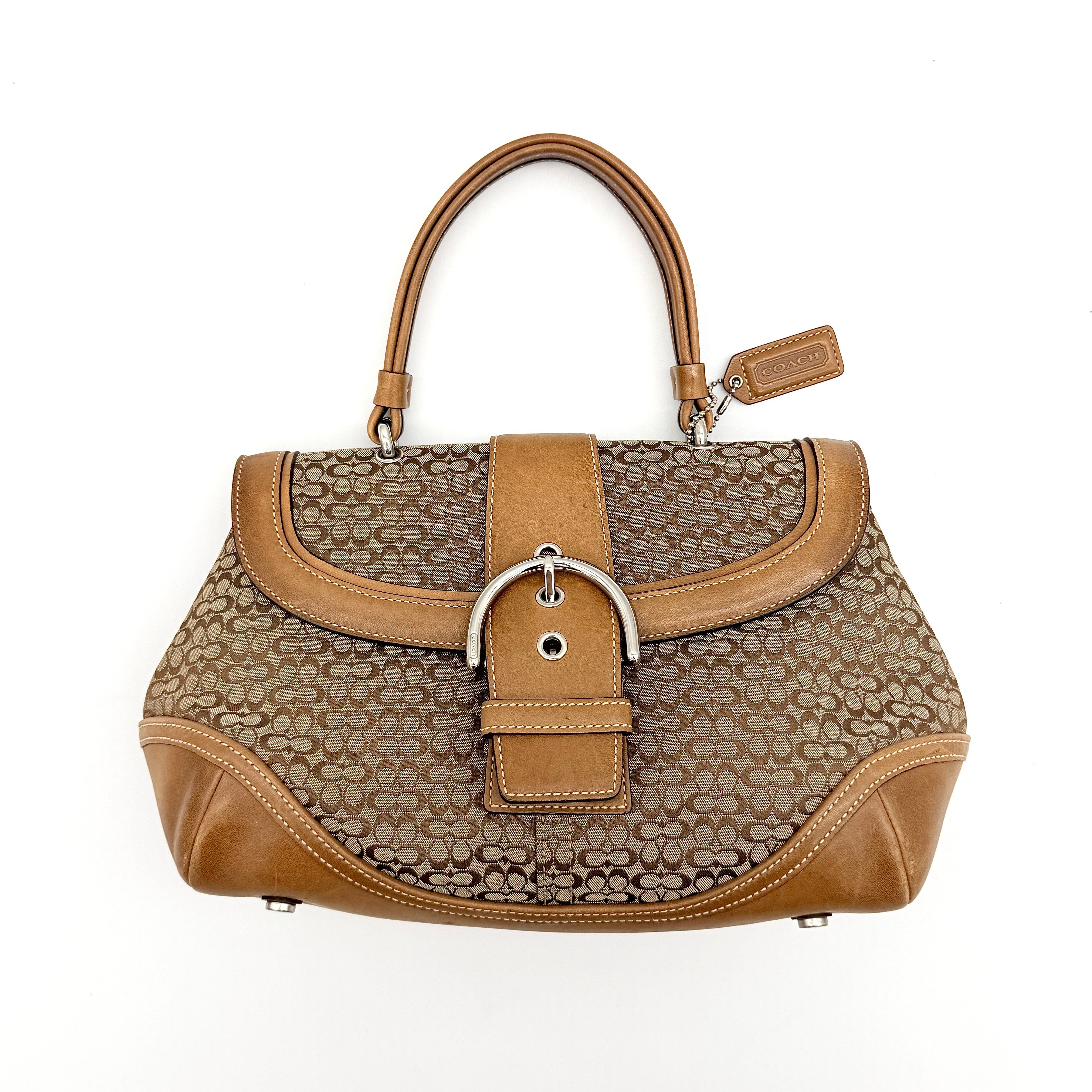 Coach Signature Soho shoulder bag in beige jacquard canvas with tan leather trim and silver buckle, shown against a white background.