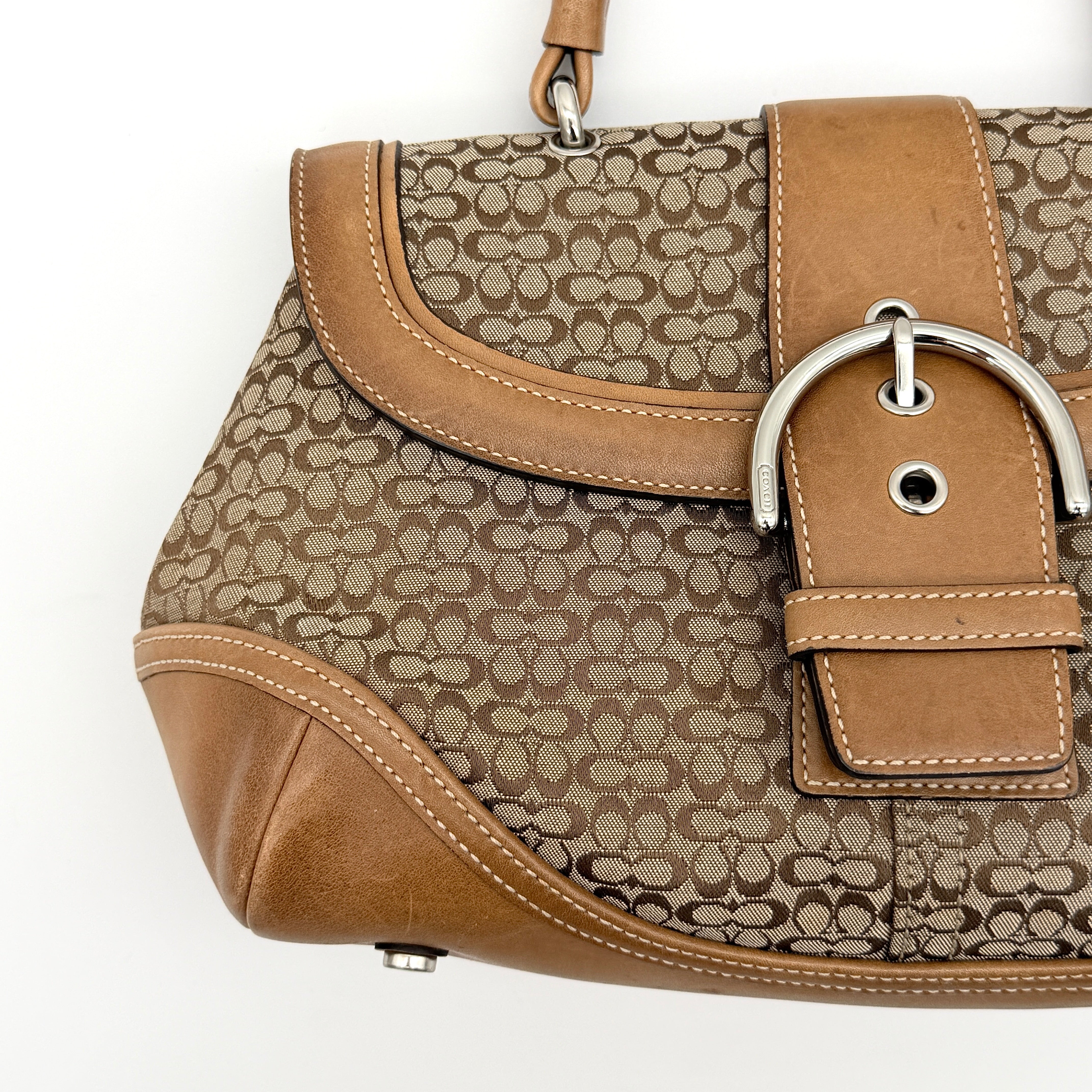 Coach Signature Soho shoulder bag in beige jacquard canvas with tan leather trim and silver buckle, shown against a white background.