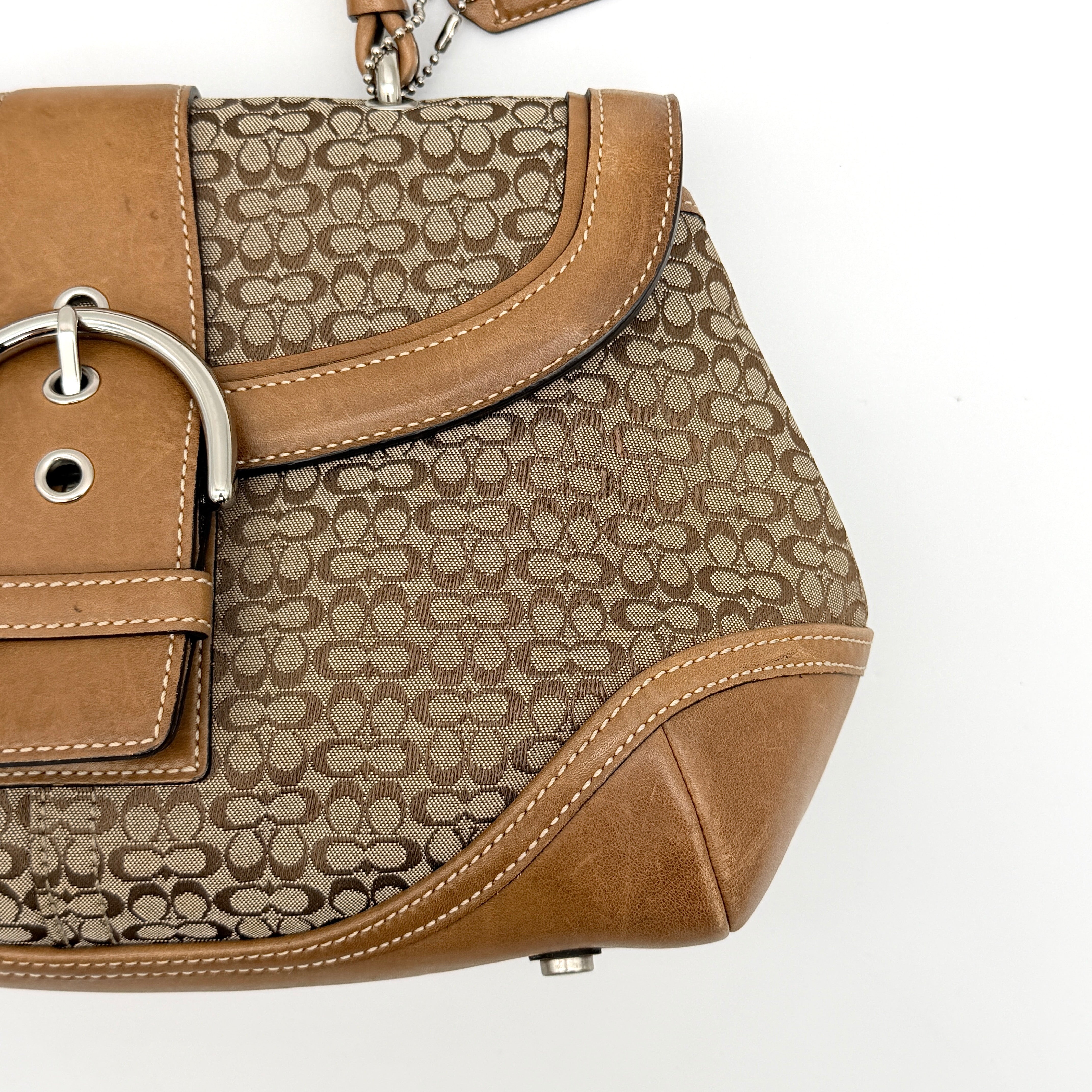 Coach Signature Soho shoulder bag in beige jacquard canvas with tan leather trim and silver buckle, shown against a white background.