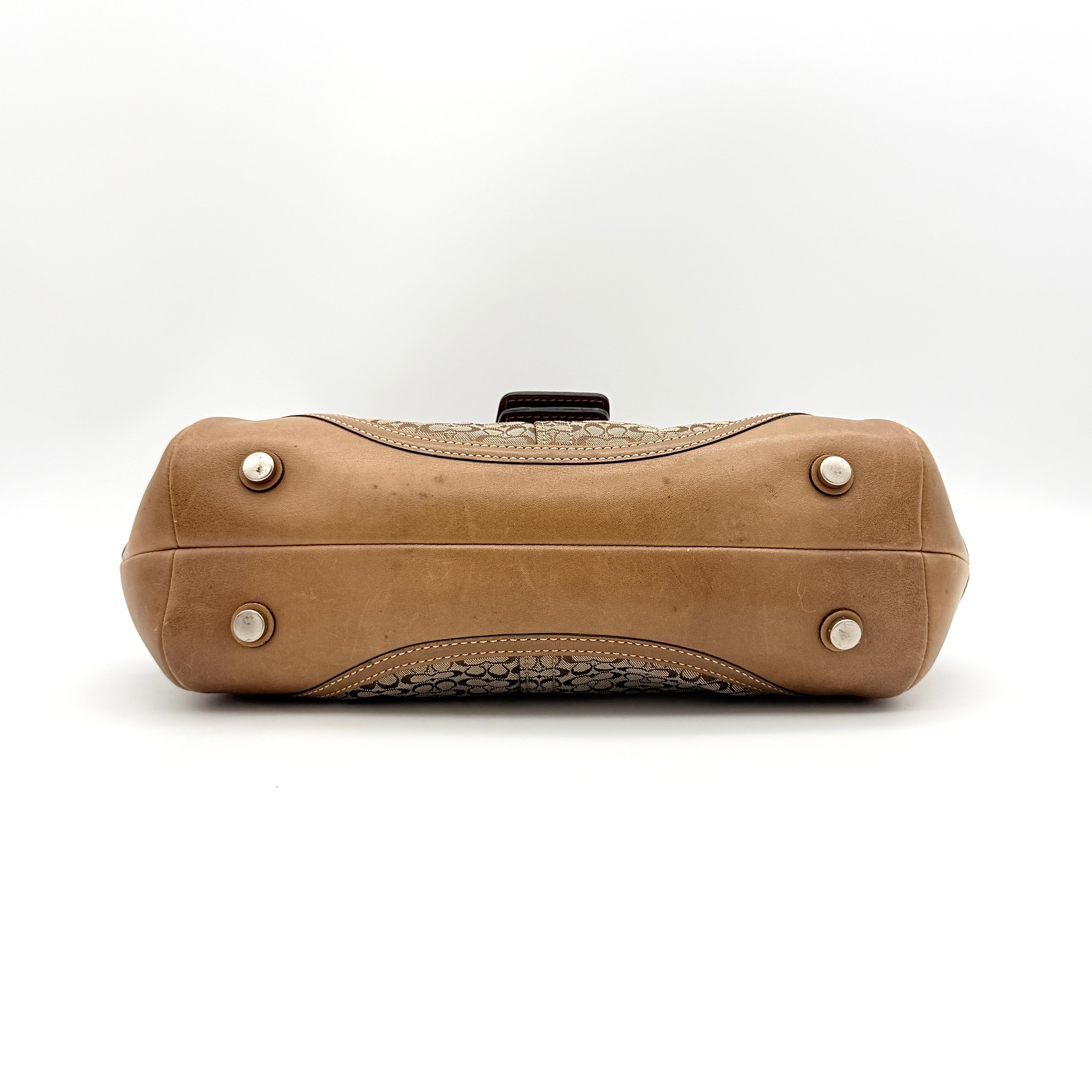 Coach Signature Soho shoulder bag in beige jacquard canvas with tan leather trim and silver buckle, shown against a white background.