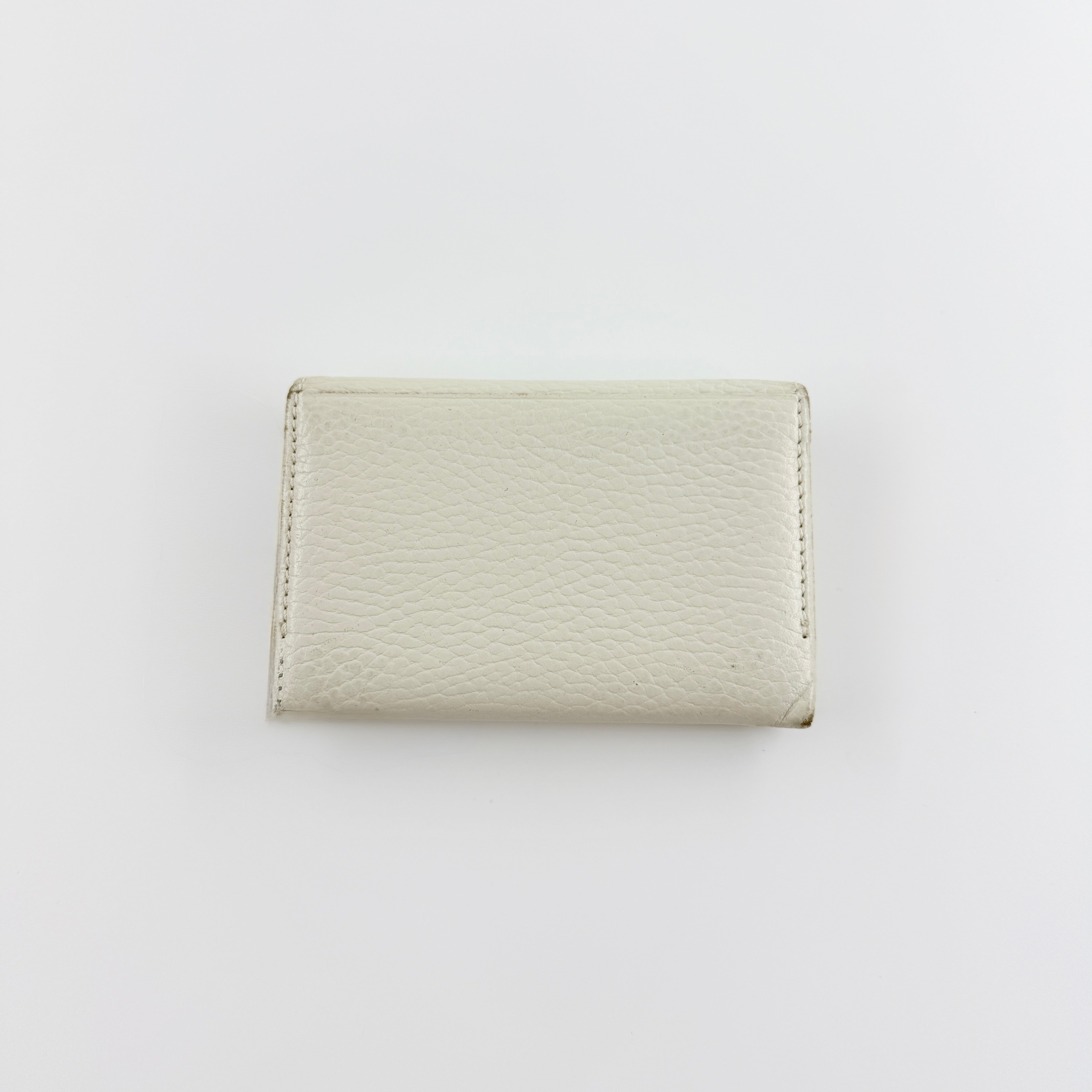 Burberry Nova Check card holder in ivory grained leather with subtle embossed logo, presented closed against a clean background.