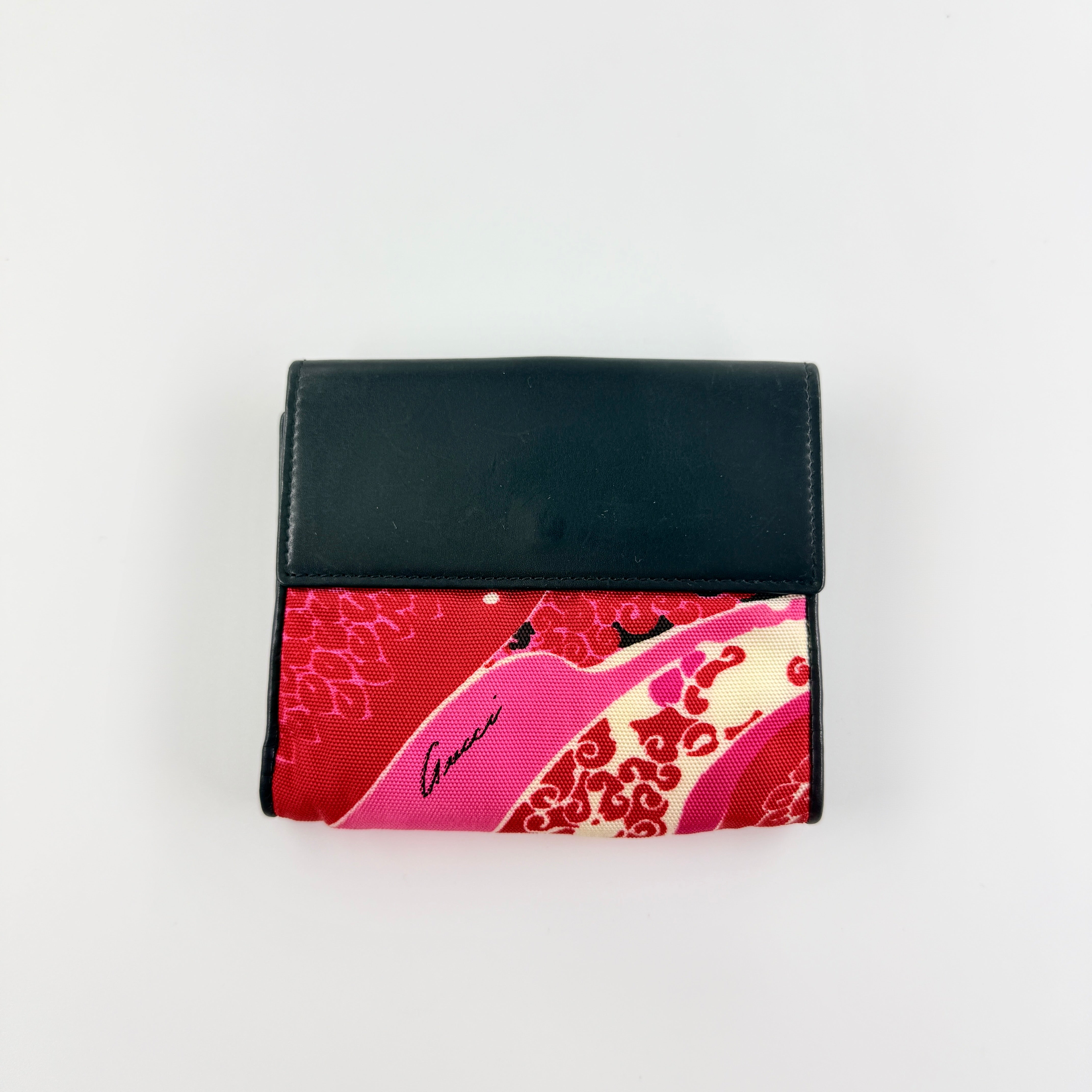 Gucci compact wallet with vibrant pink floral canvas, black leather trim and a silver-tone clasp, front view.