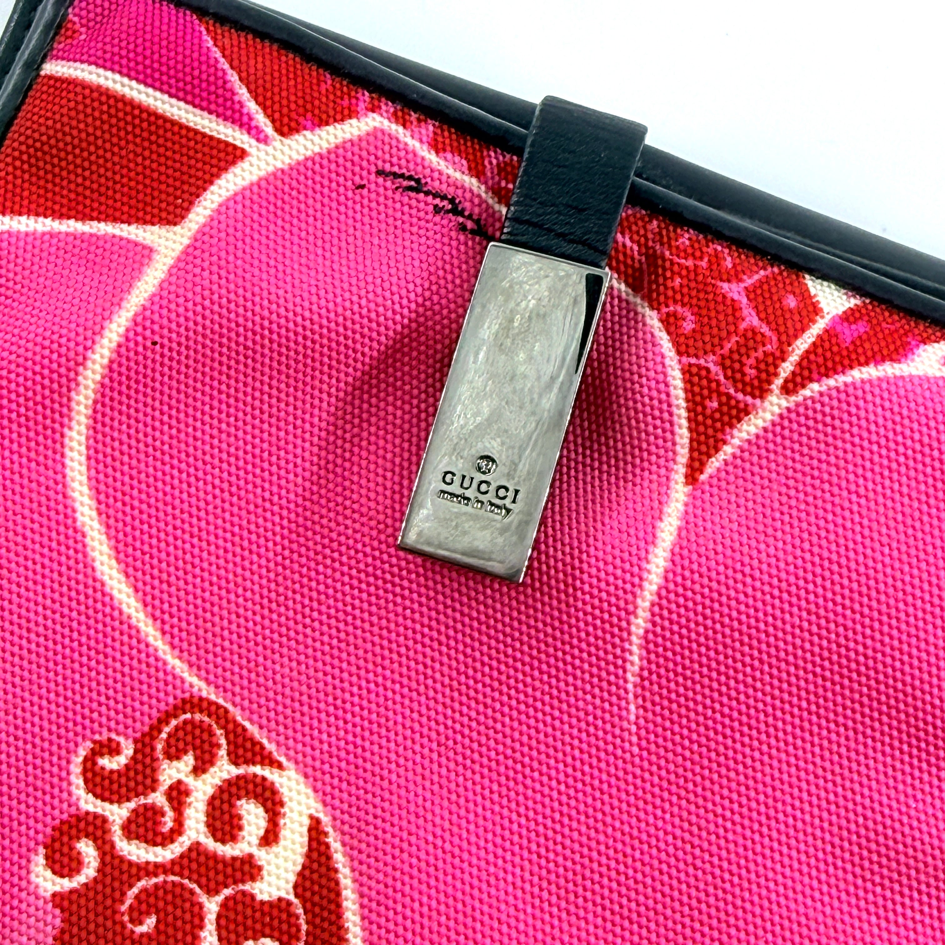 Gucci compact wallet with vibrant pink floral canvas, black leather trim and a silver-tone clasp, front view.