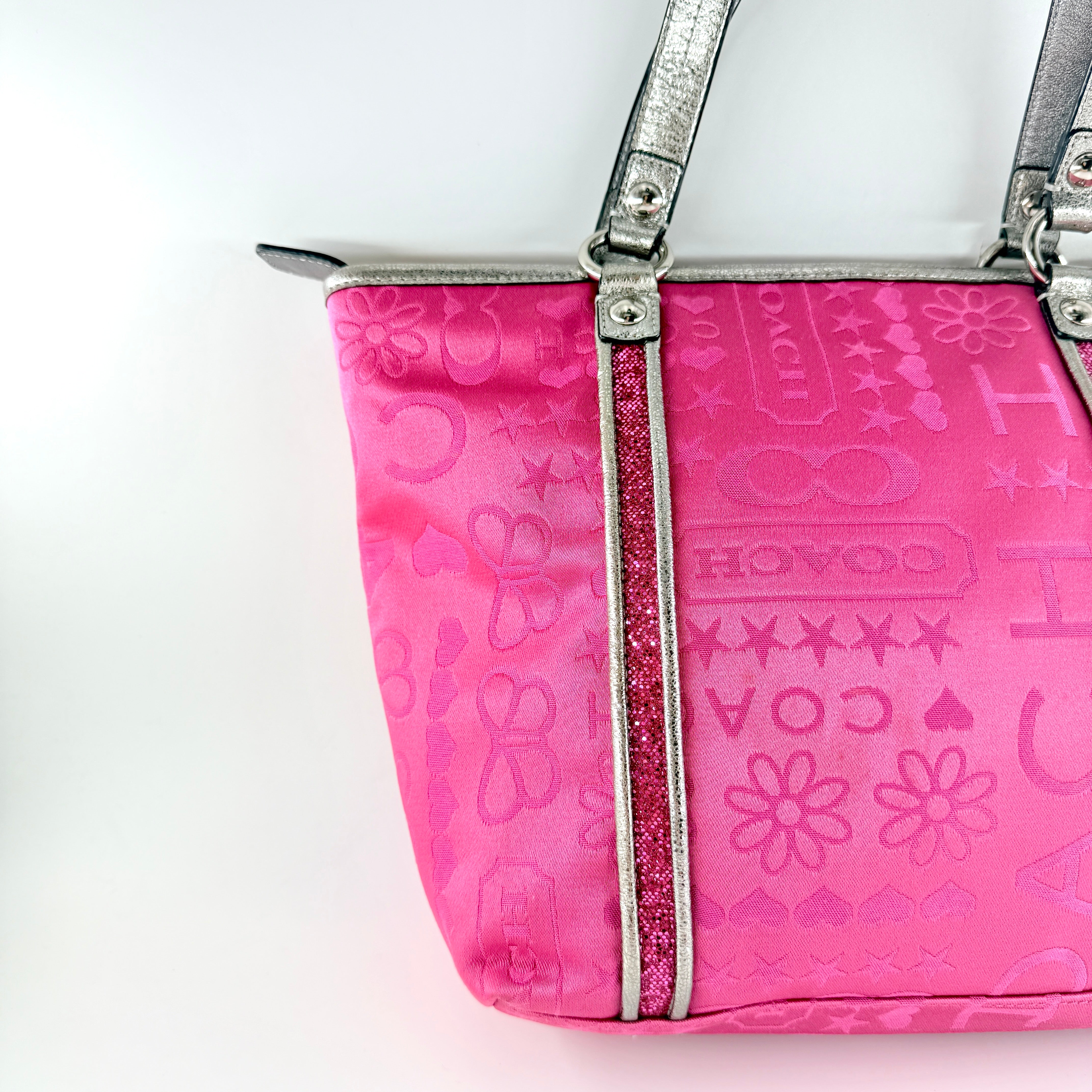 Coach Poppy Bandana Glitter Graffiti Tote Bag in vibrant pink with metallic silver handles, adorned with glitter accents and butterfly charm.