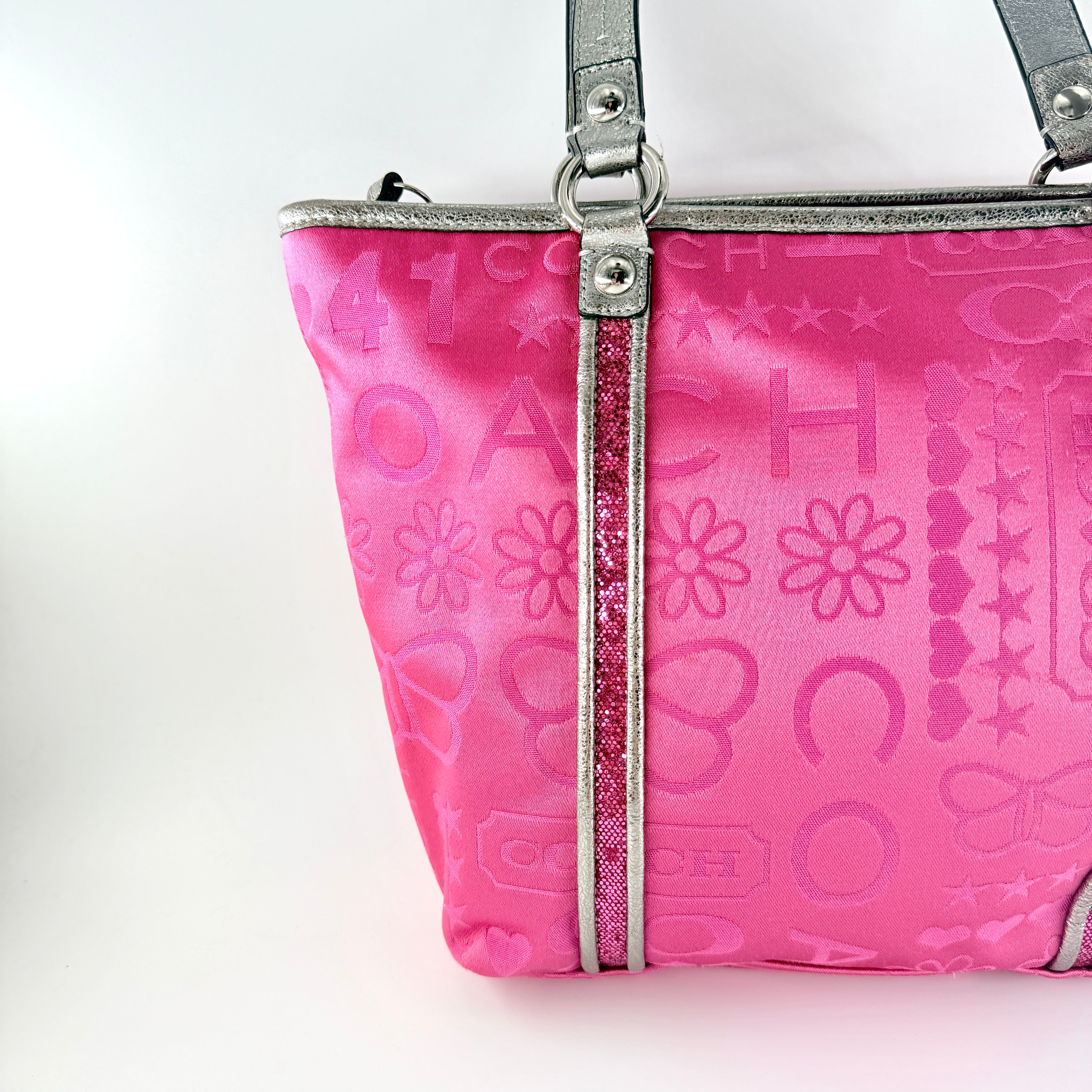 Coach Poppy Bandana Glitter Graffiti Tote Bag in vibrant pink with metallic silver handles, adorned with glitter accents and butterfly charm.