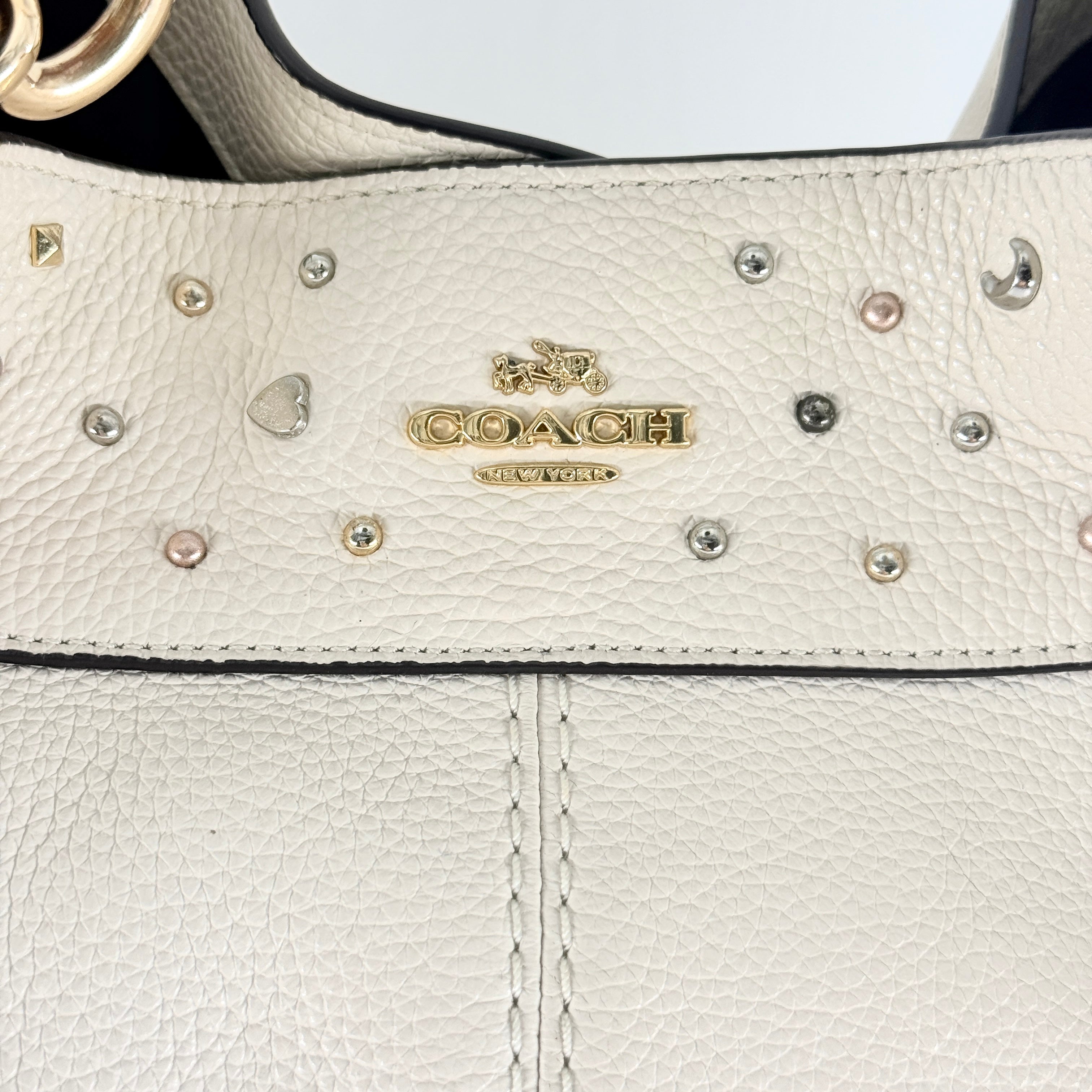 Coach Lexy Stardust Studded Chalk Hobo in ivory pebbled leather, adorned with mixed metal studs and dual handles.
