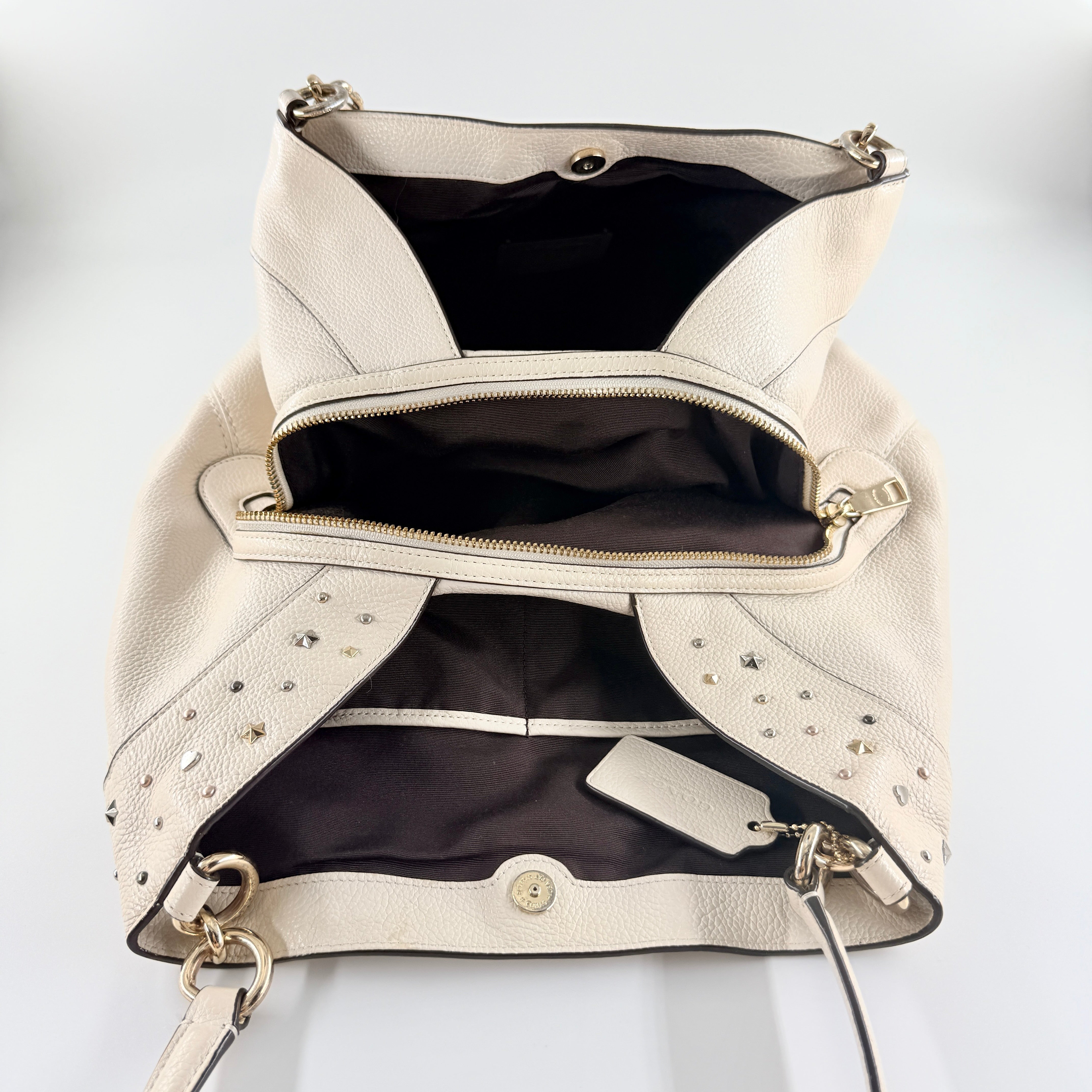 Coach Lexy Stardust Studded Chalk Hobo in ivory pebbled leather, adorned with mixed metal studs and dual handles.