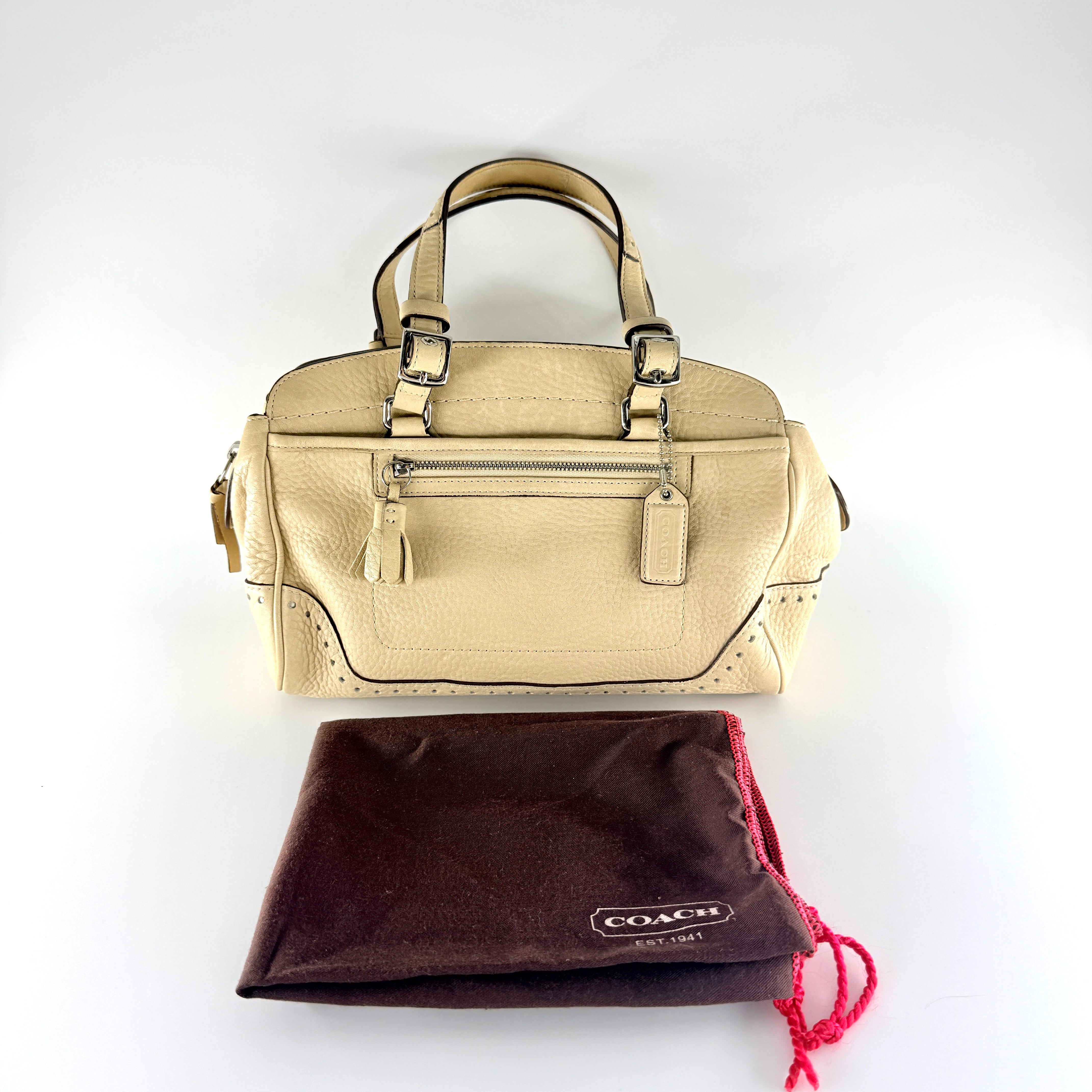 Coach Hampton Sand Satchel in beige pebbled leather with structured dual handles, front zip pocket, and silver-tone hardware.