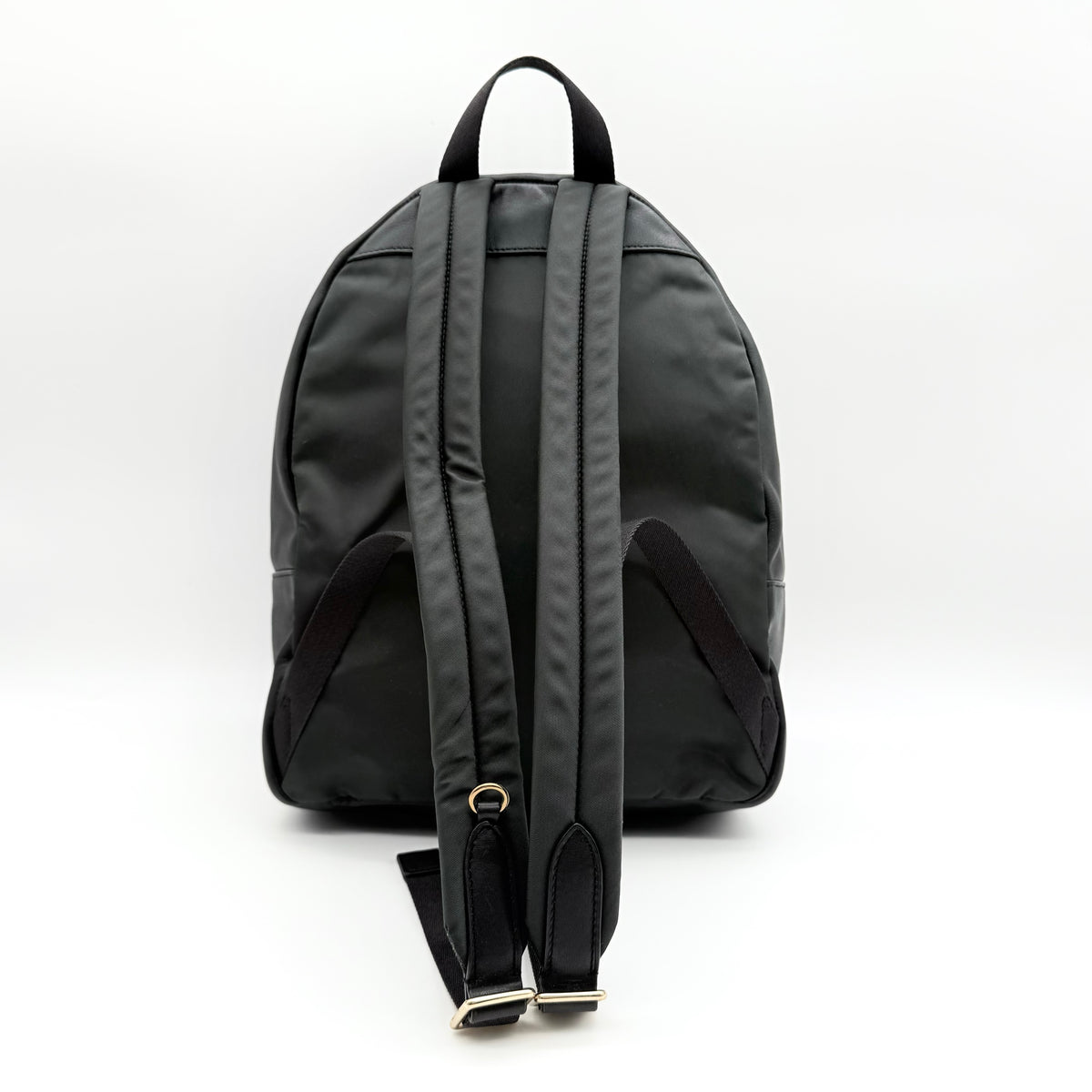 Coach Signature Charlie Backpack in brown and black canvas with gold-tone hardware and front zip pocket.